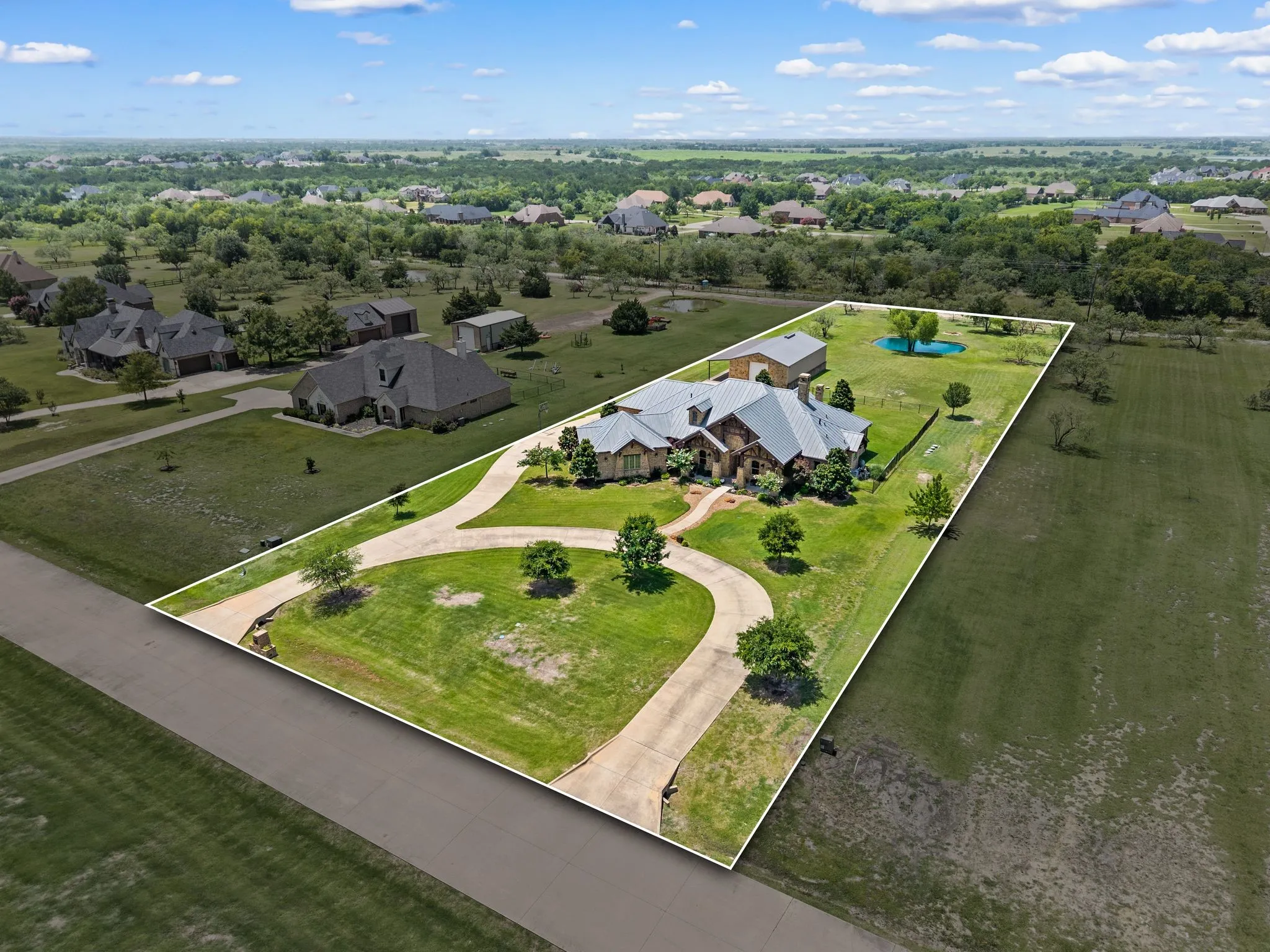 Expansive acreage offers incredible privacy, a circular drive, large workshop or outbuilding & a picturesque pond.