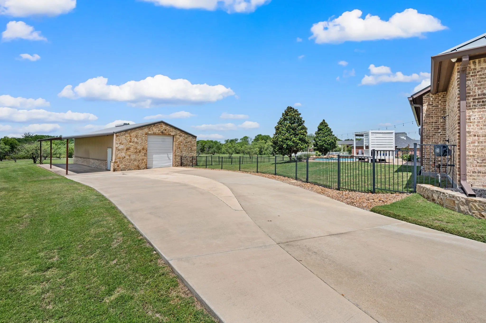 The extended driveway leads to a substantial detached workshop with a roll-up door, covered side area & excellent space for equipment or recreational vehicles. There is also a bathroom inside!
