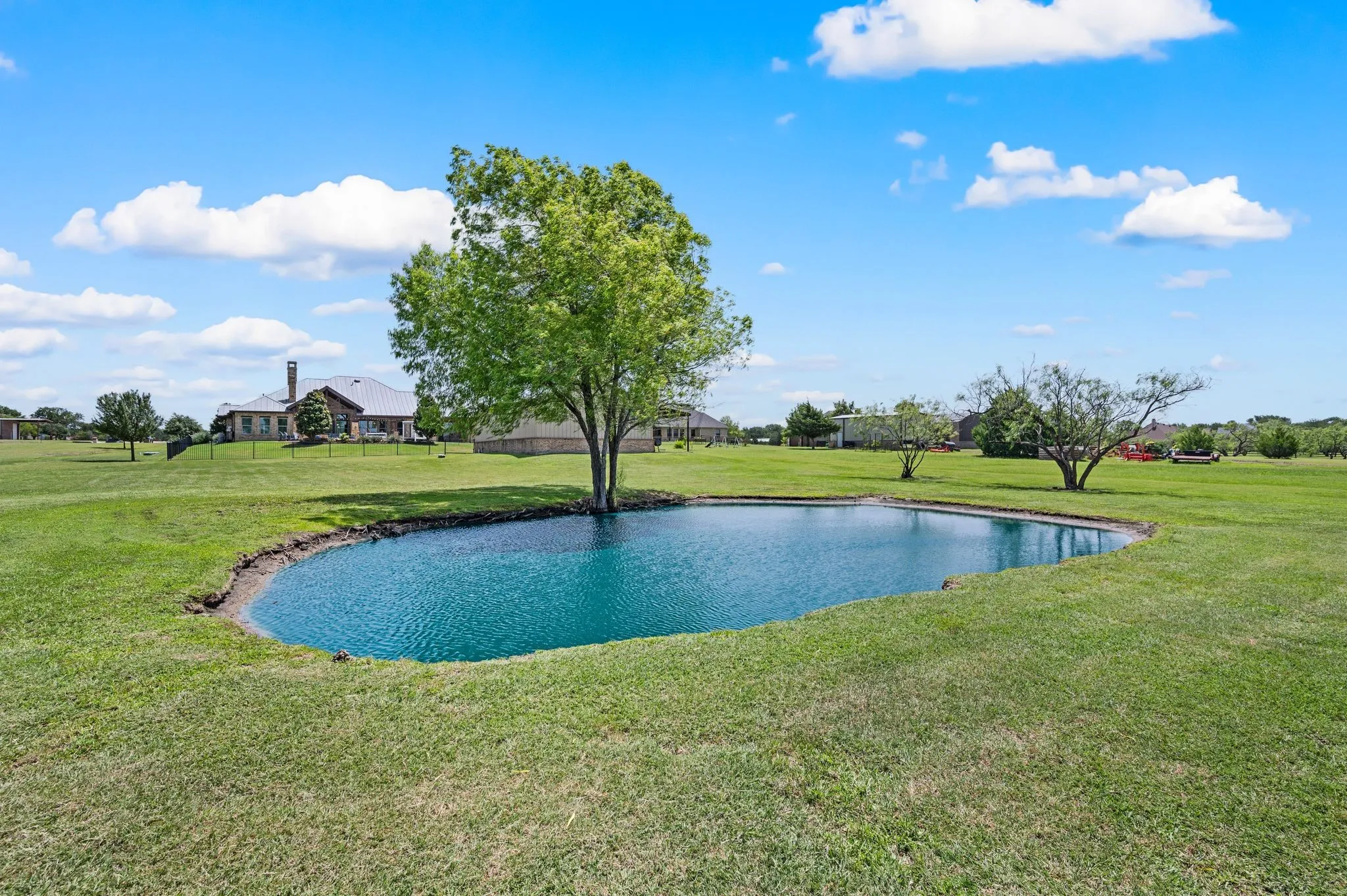 A picturesque private pond adds natural beauty and a peaceful focal point to the expansive grounds.