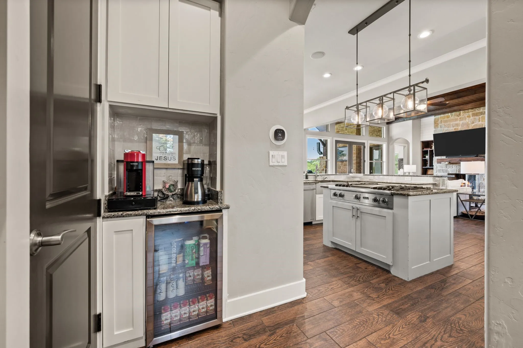 A convenient beverage station includes additional cabinetry, granite countertops & an undercounter refrigerator for effortless entertaining.