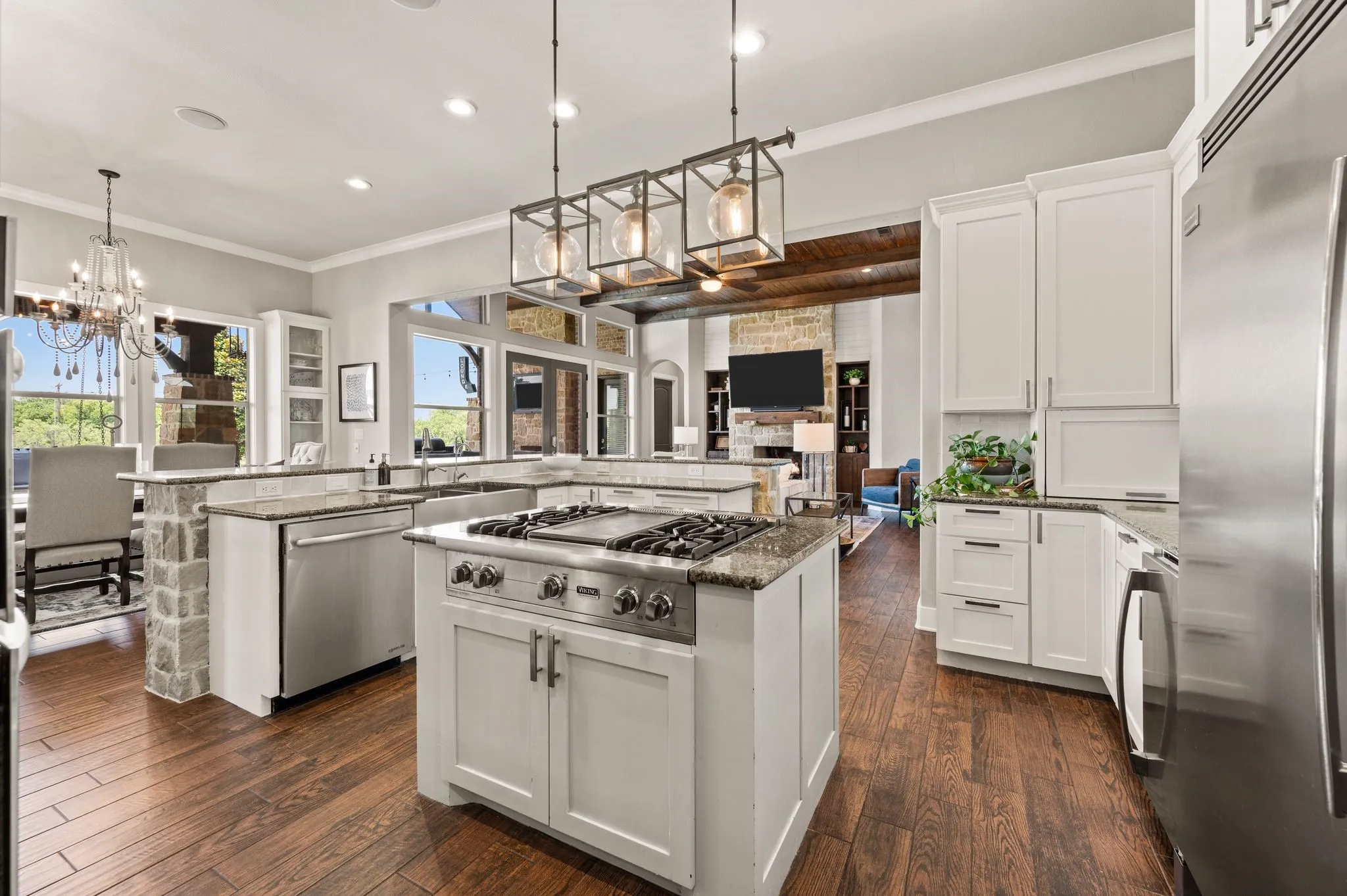 The chef’s kitchen shines with premium stainless steel appliances, an oversized built in fridge, a statement island light fixture & open views into the main living spaces