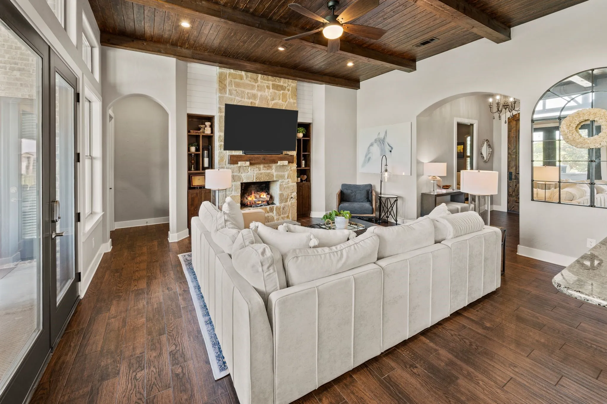 Gather around the striking floor-to-ceiling stone fireplace, complete with built-ins, a wood mantel & a warm, welcoming atmosphere.
