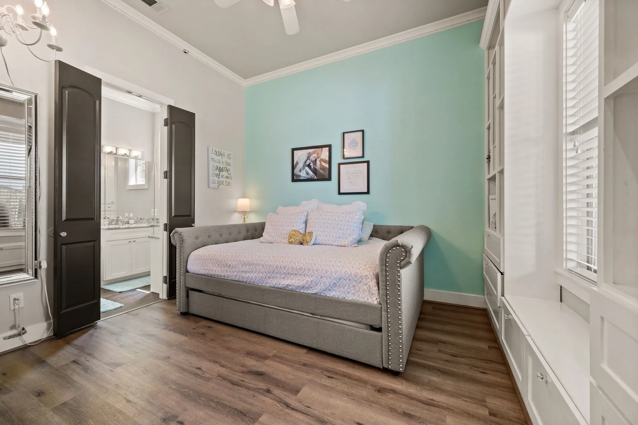 This cheerful secondary bedroom includes an ensuite bathroom, built-in cabinetry & plenty of natural light.
