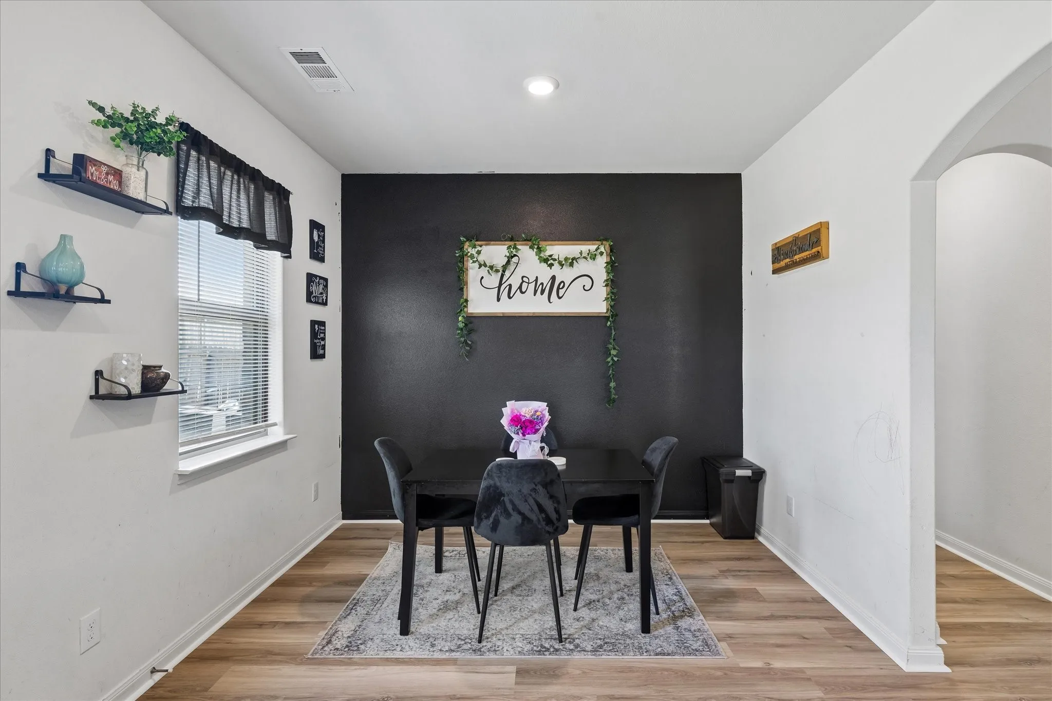 Wood-finish flooring, recessed lighting, and an arched entry