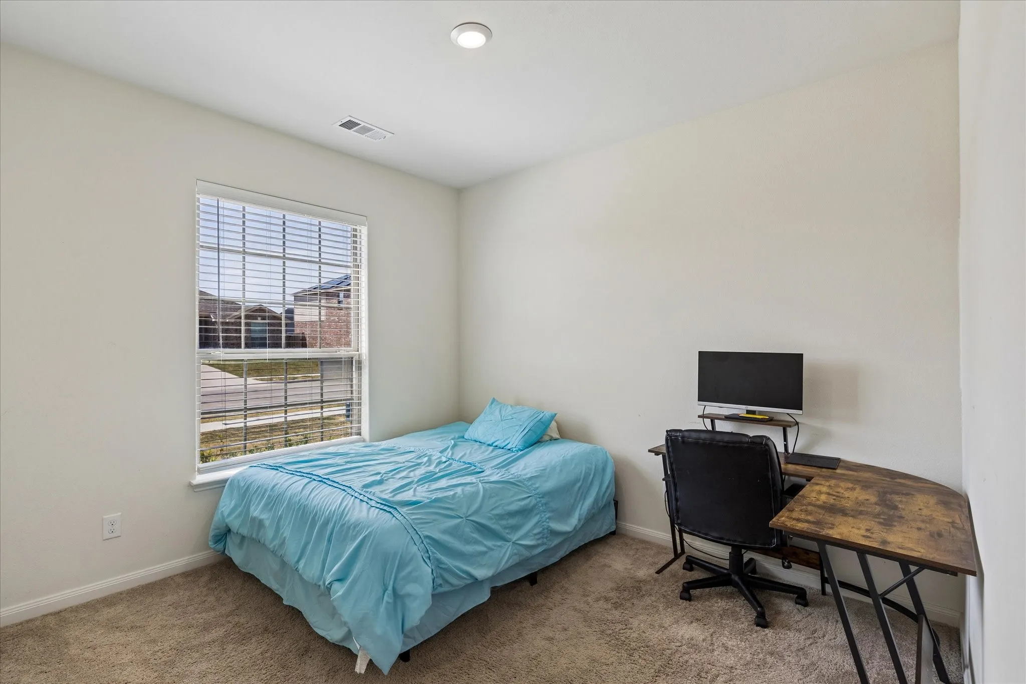 Recessed ceiling lighting, a single window with blinds, and neutral wall paint