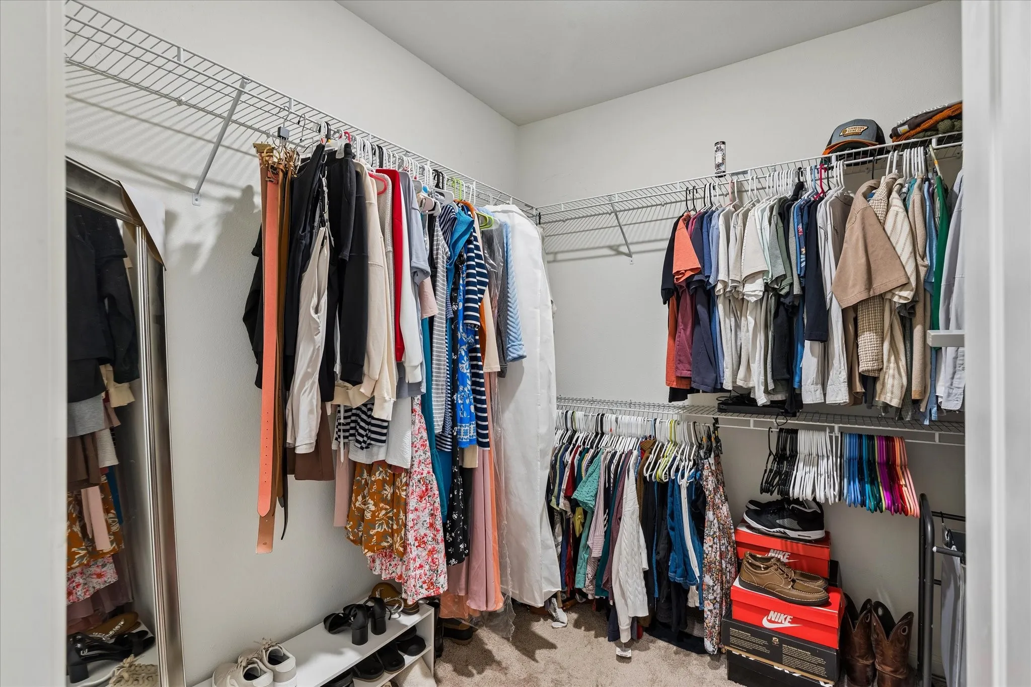 Walk-in closet featuring wire shelving, multiple hanging rods, and an integrated full-length mirror