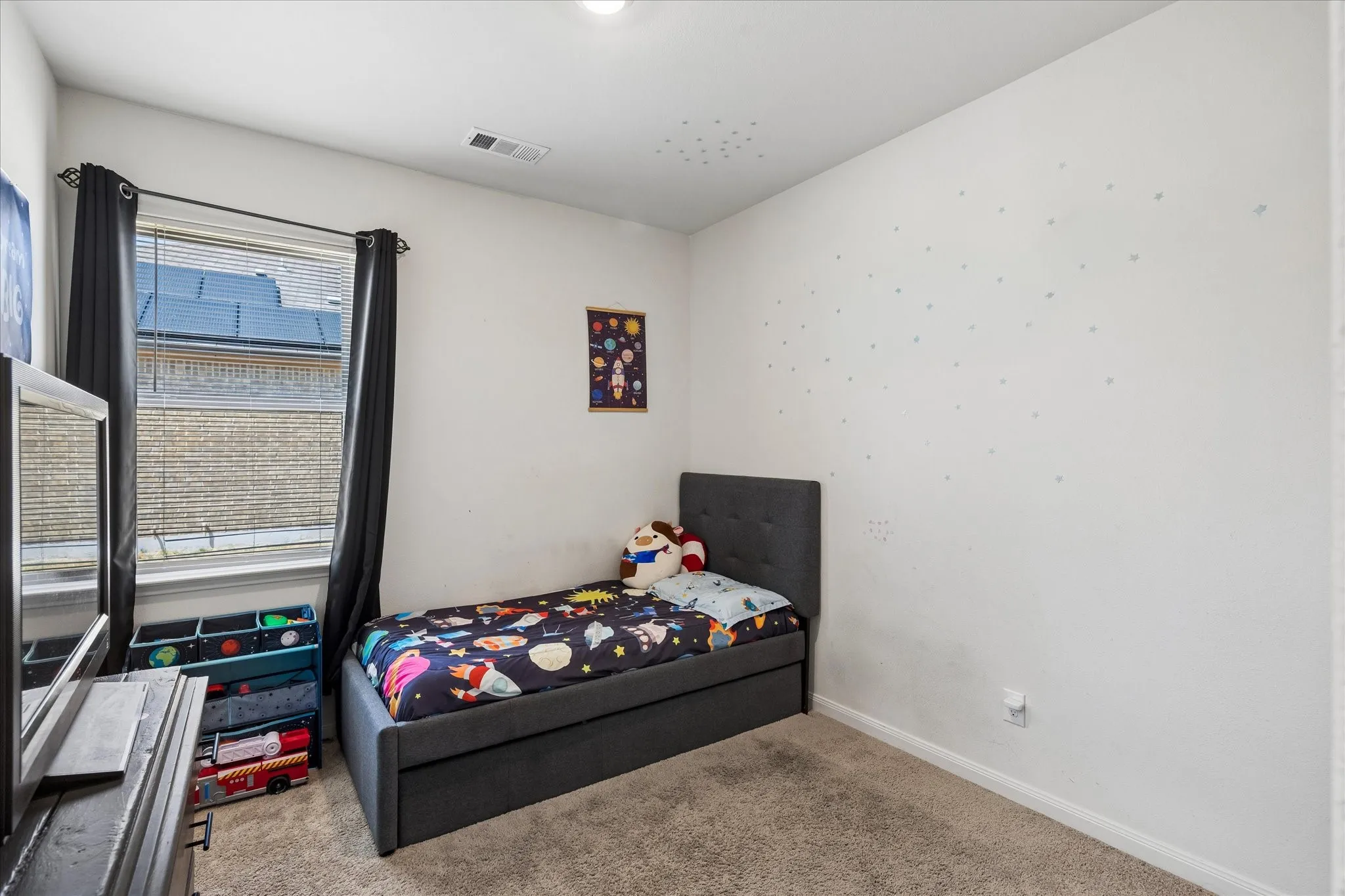 Carpeted flooring, white painted walls, a single window with blinds, and a built-in ceiling light fixture