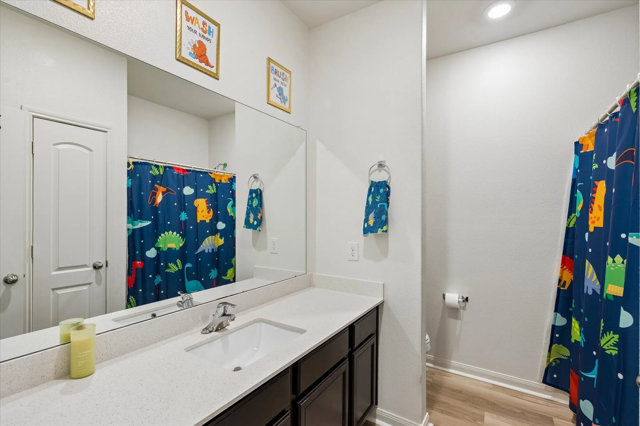 White vanity with a single basin sink, chrome faucet, and expansive mirror