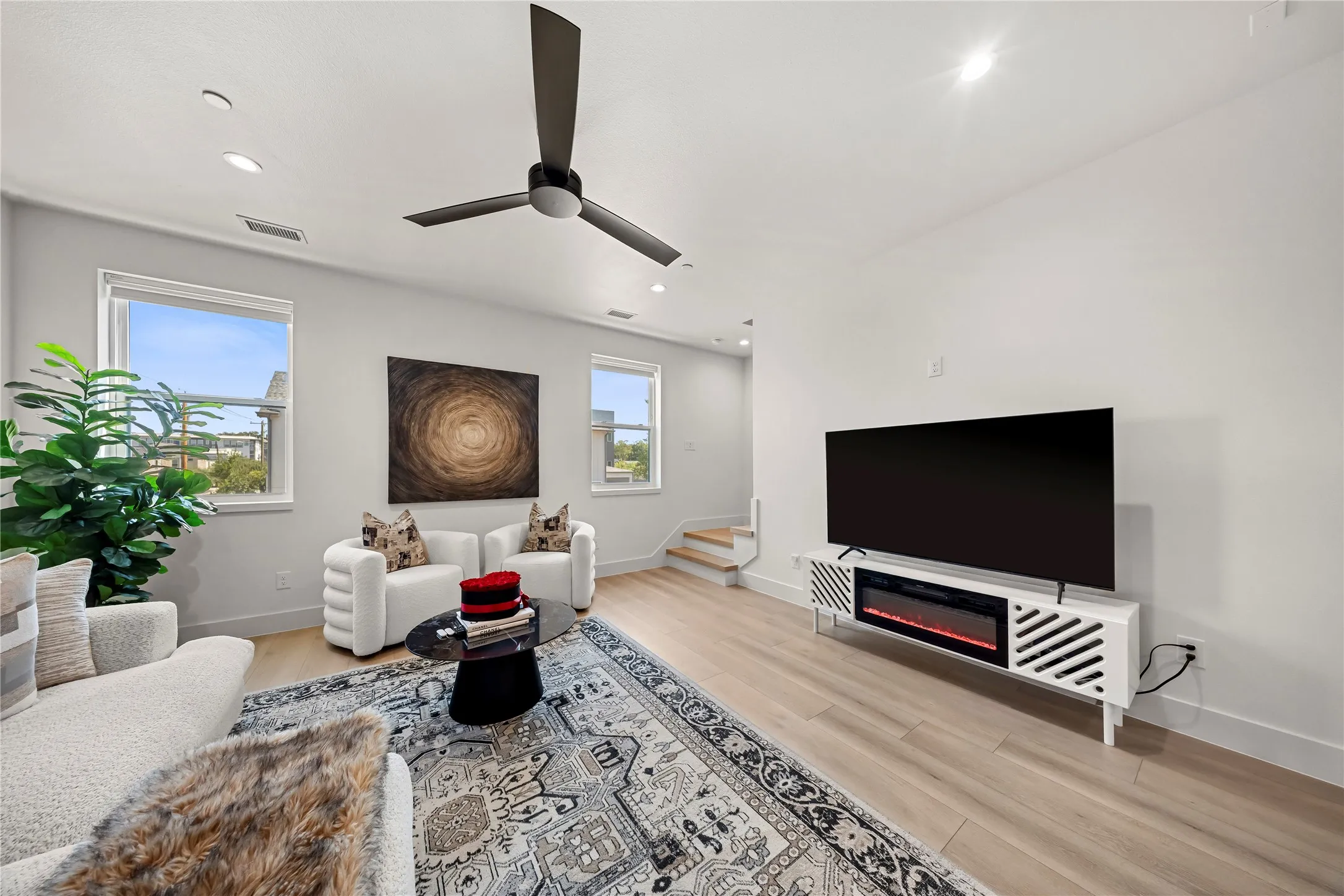 Modern kitchen featuring white countertops, wood-finish cabinetry, stainless steel appliances, and a kitchen island with a built-in sink