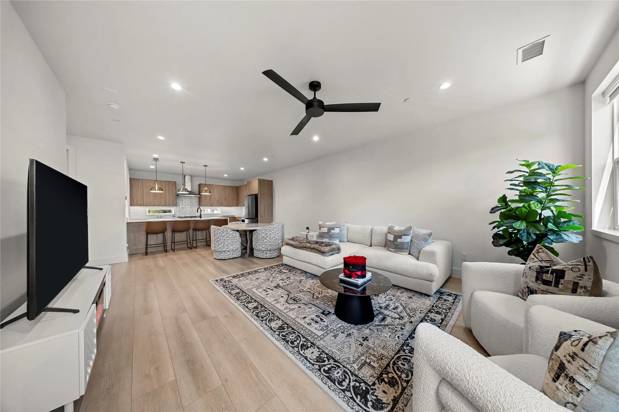 Open-concept living space featuring wood-finish flooring and recessed lighting