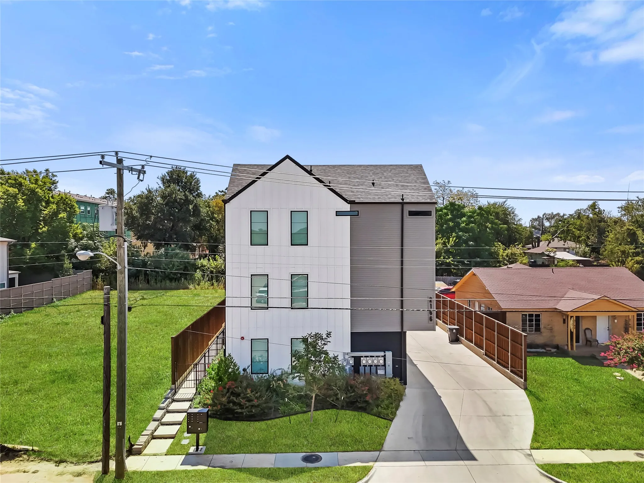 Modern architectural style with a gabled roofline and contrasting white and gray exterior siding
