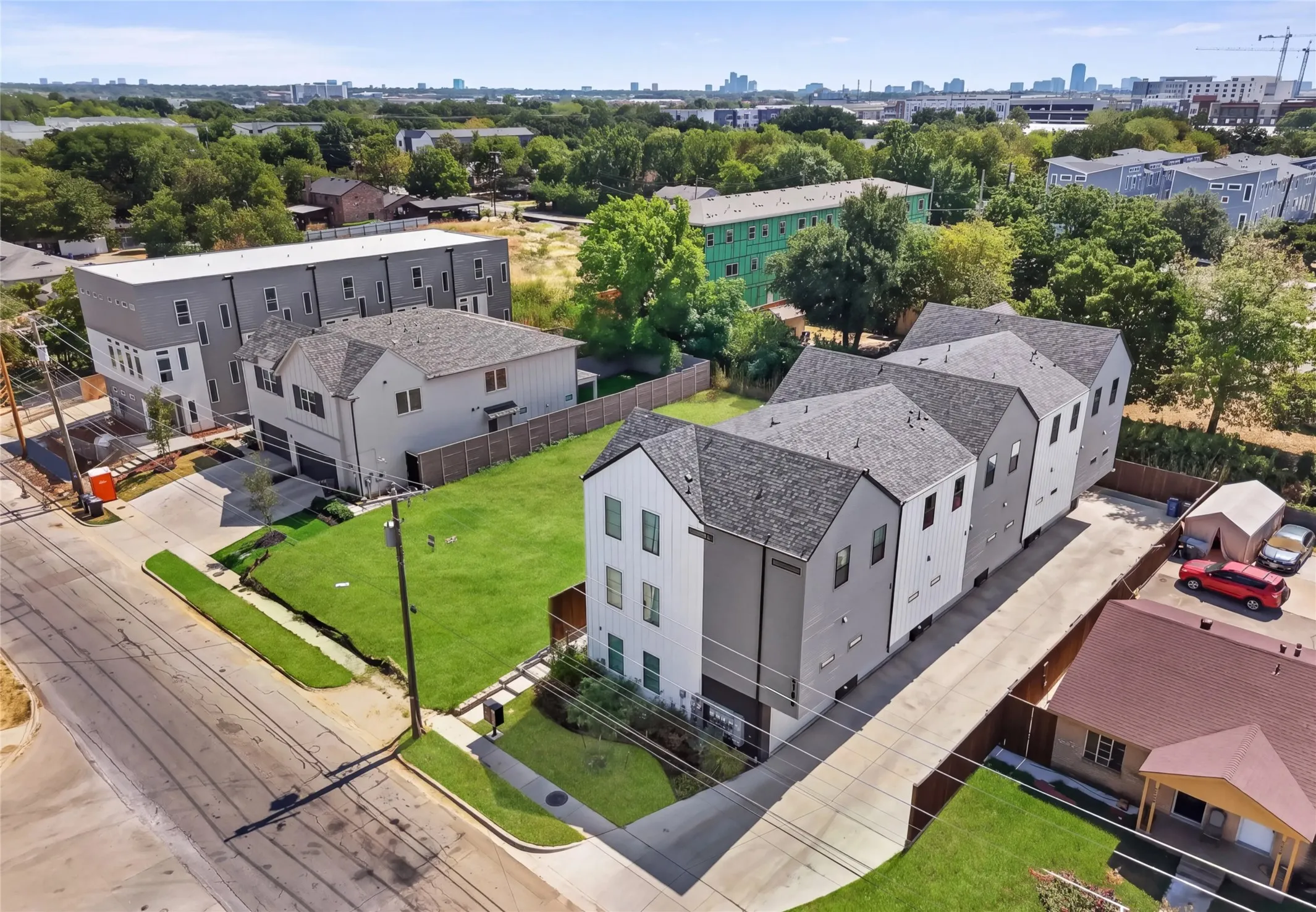 Modern townhome-style residences featuring multi-level construction, distinct architectural facades, and individual parking areas