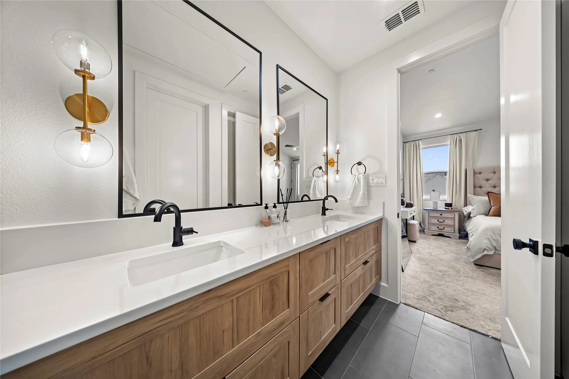 Dual vanity with wood-finish cabinetry, integrated rectangular sinks, and matte black fixtures