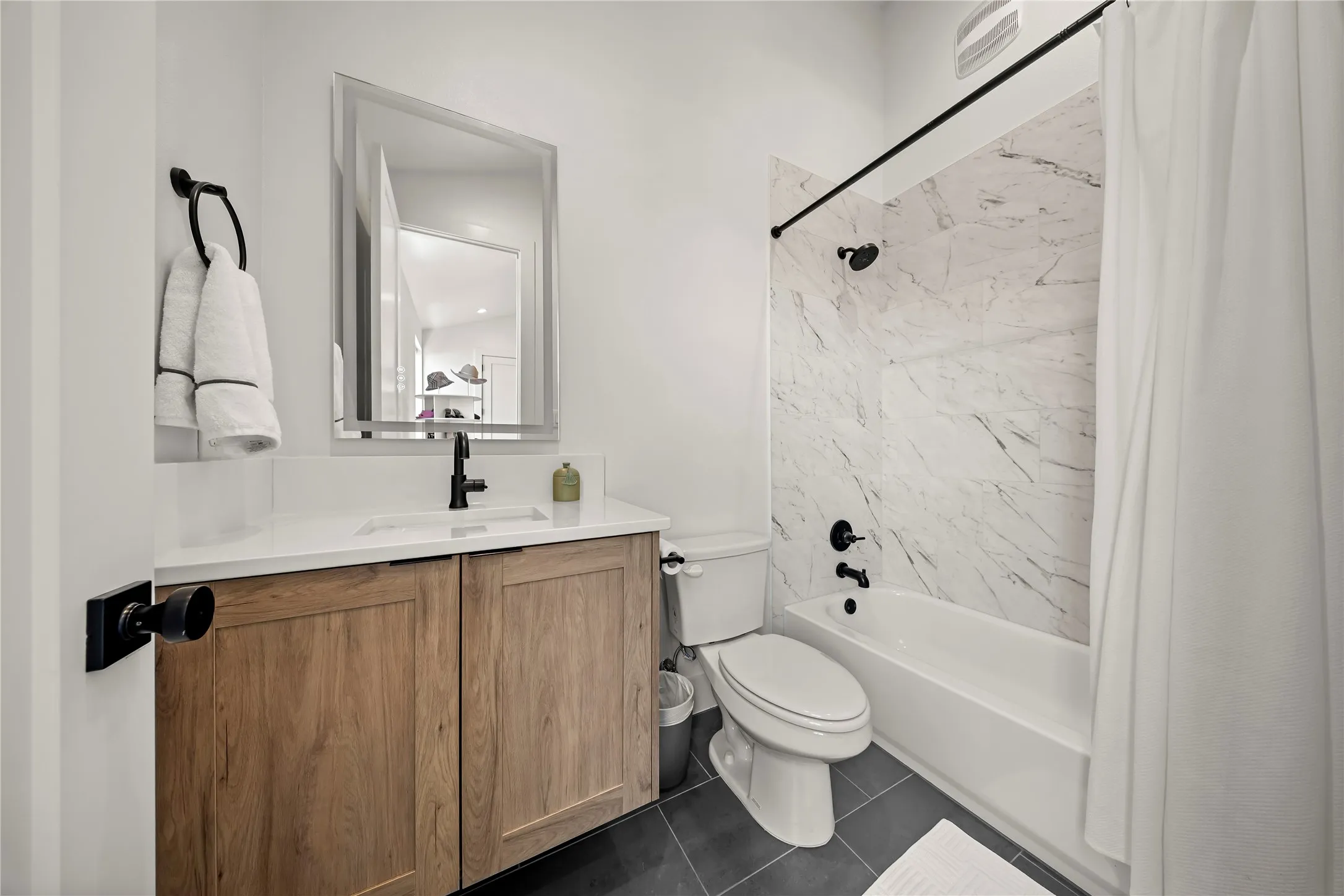 Wood-finish vanity with an integrated sink and white countertop