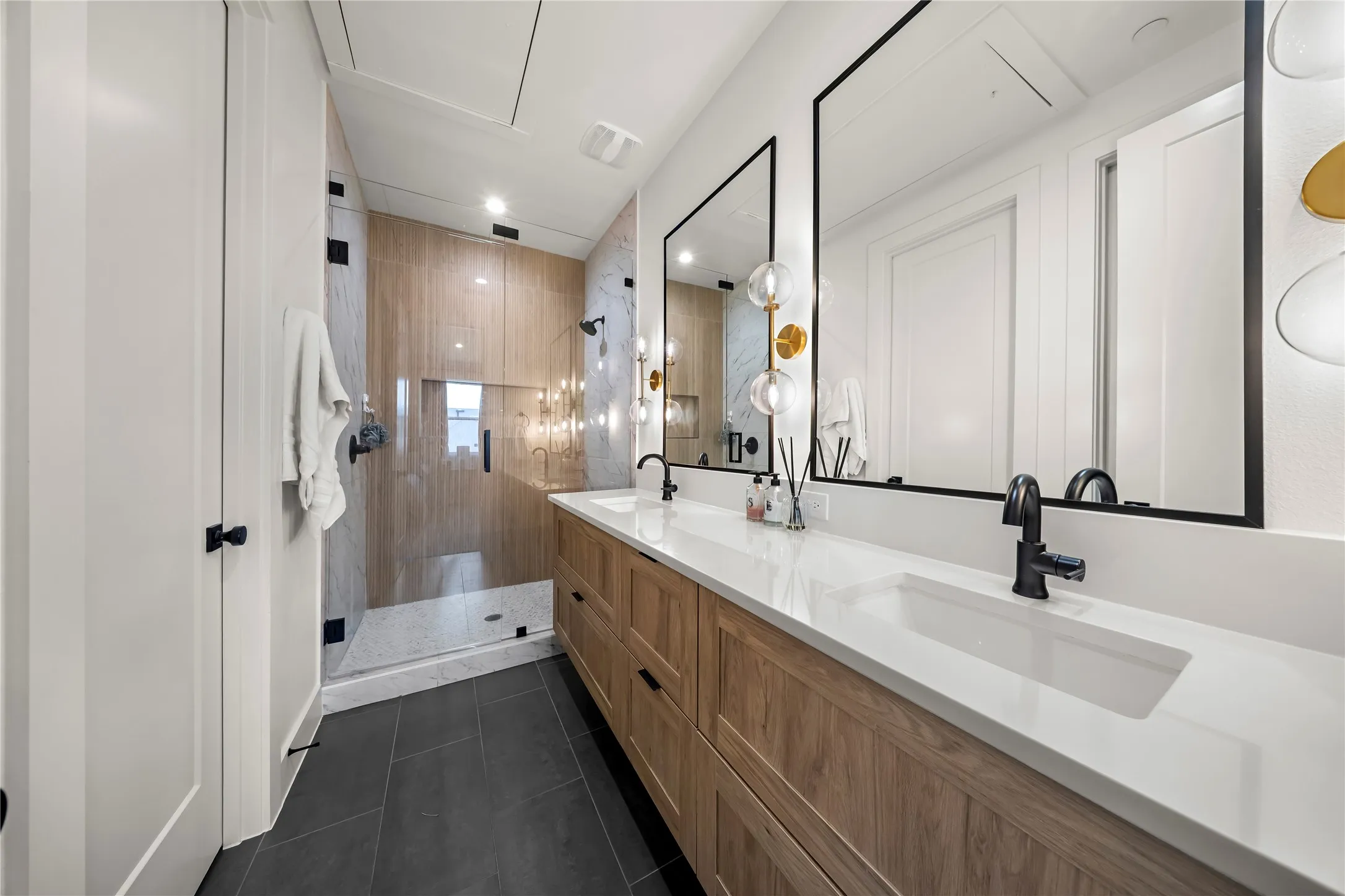 Dual vanity with rectangular sinks, wood-finish cabinetry, and matte black fixtures