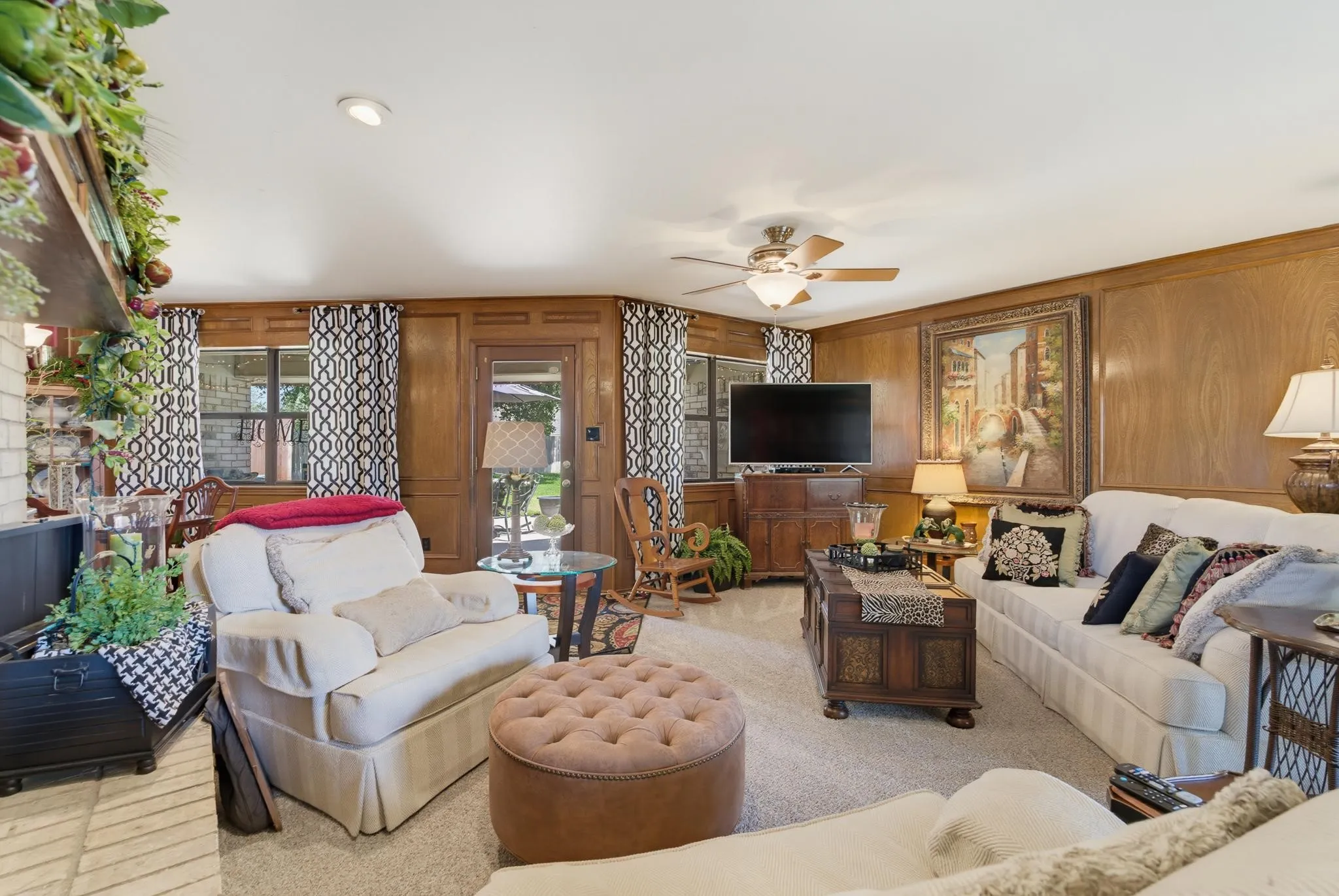 Wood-paneled walls, recessed lighting, and a ceiling fan with integrated lighting
