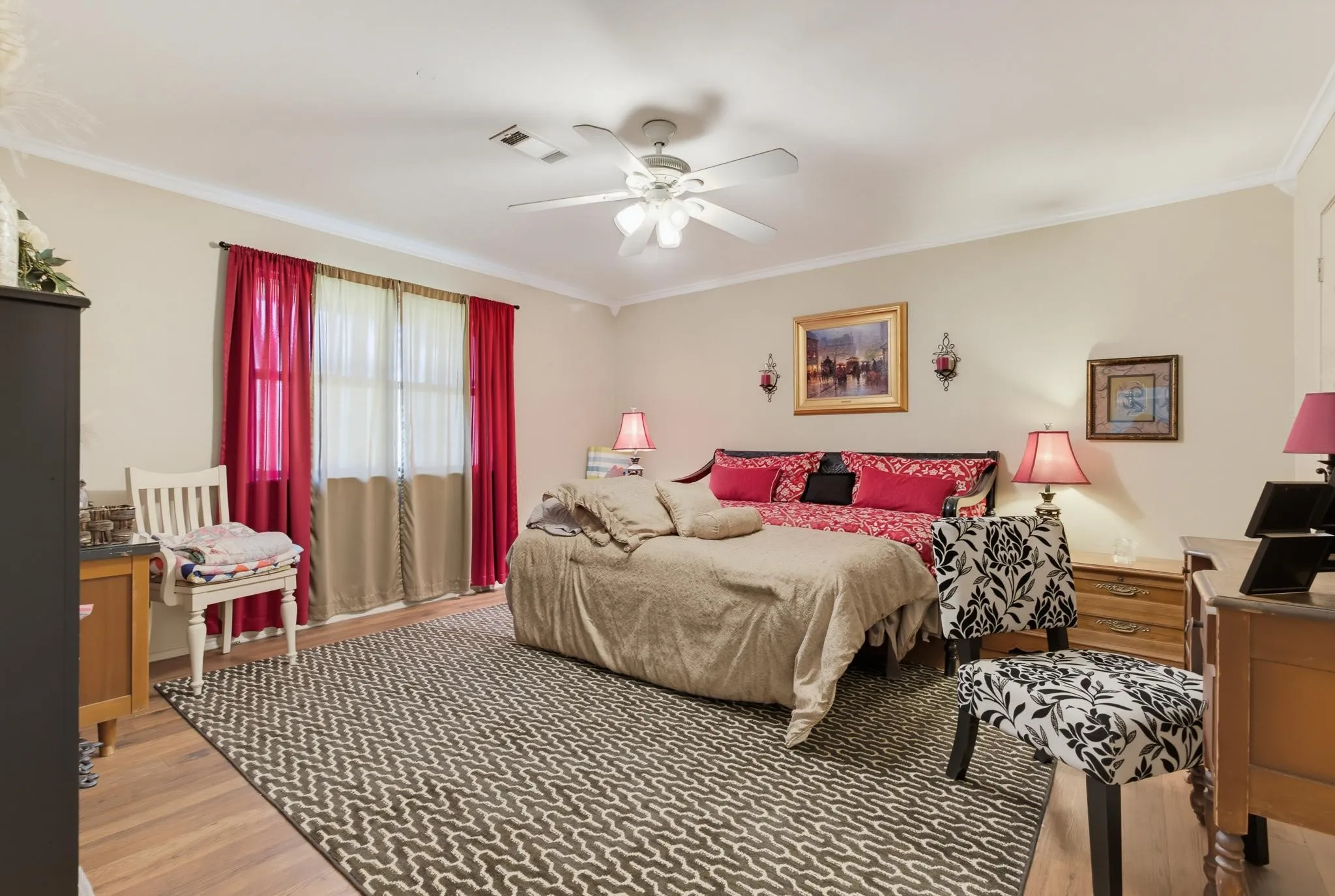 Recessed ceiling with a ceiling fan, light-toned walls, and wood-finish flooring