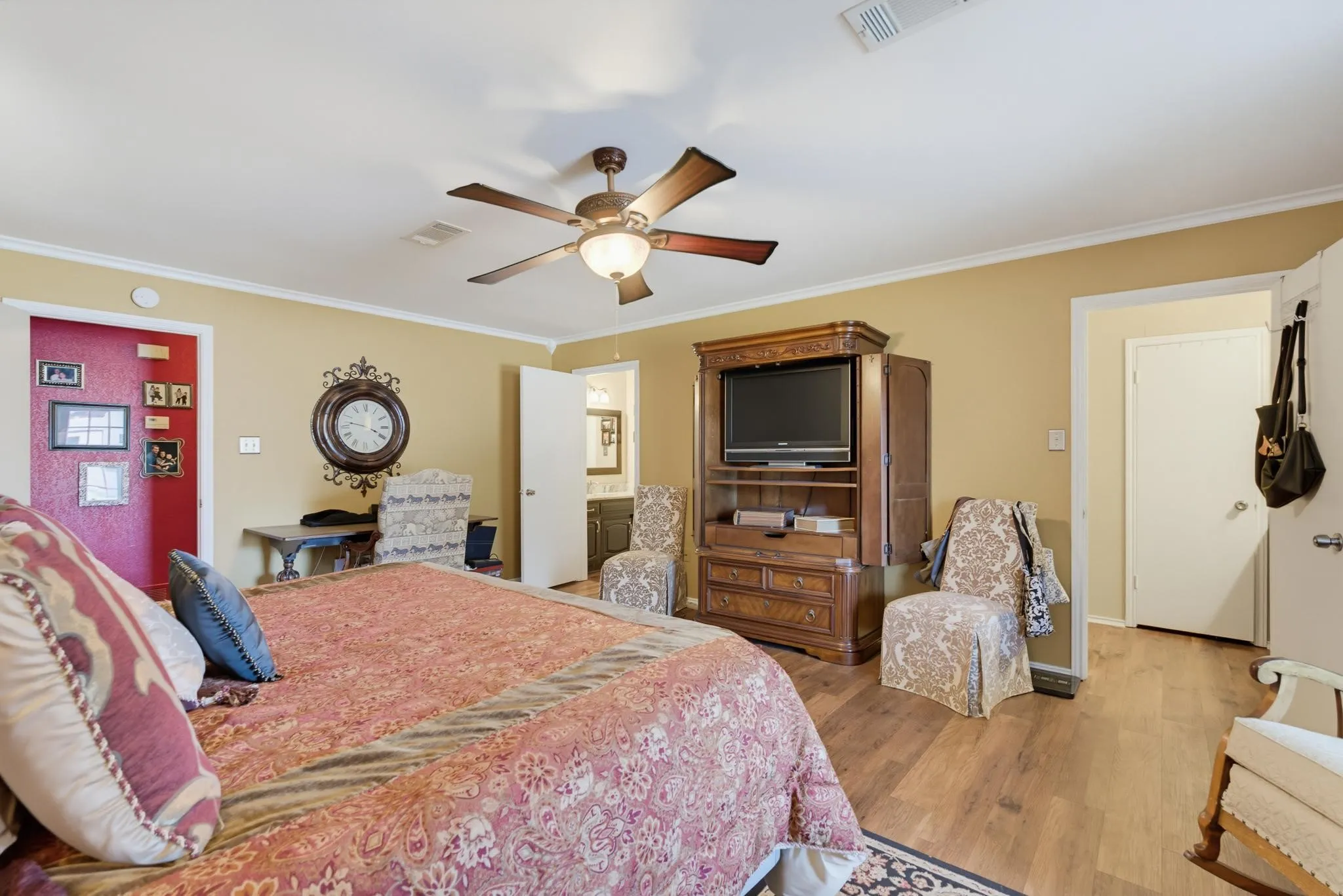 Wood-finish flooring throughout, ceiling fan with integrated lighting, and a neutral wall color