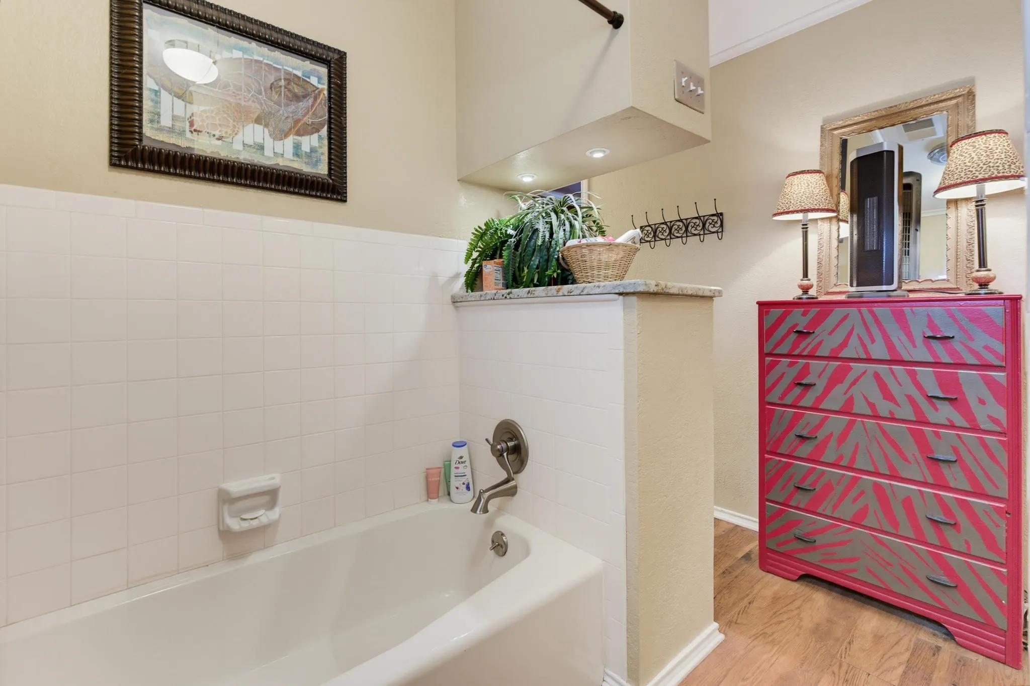 White tiled bathtub with a wall-mounted showerhead and faucet