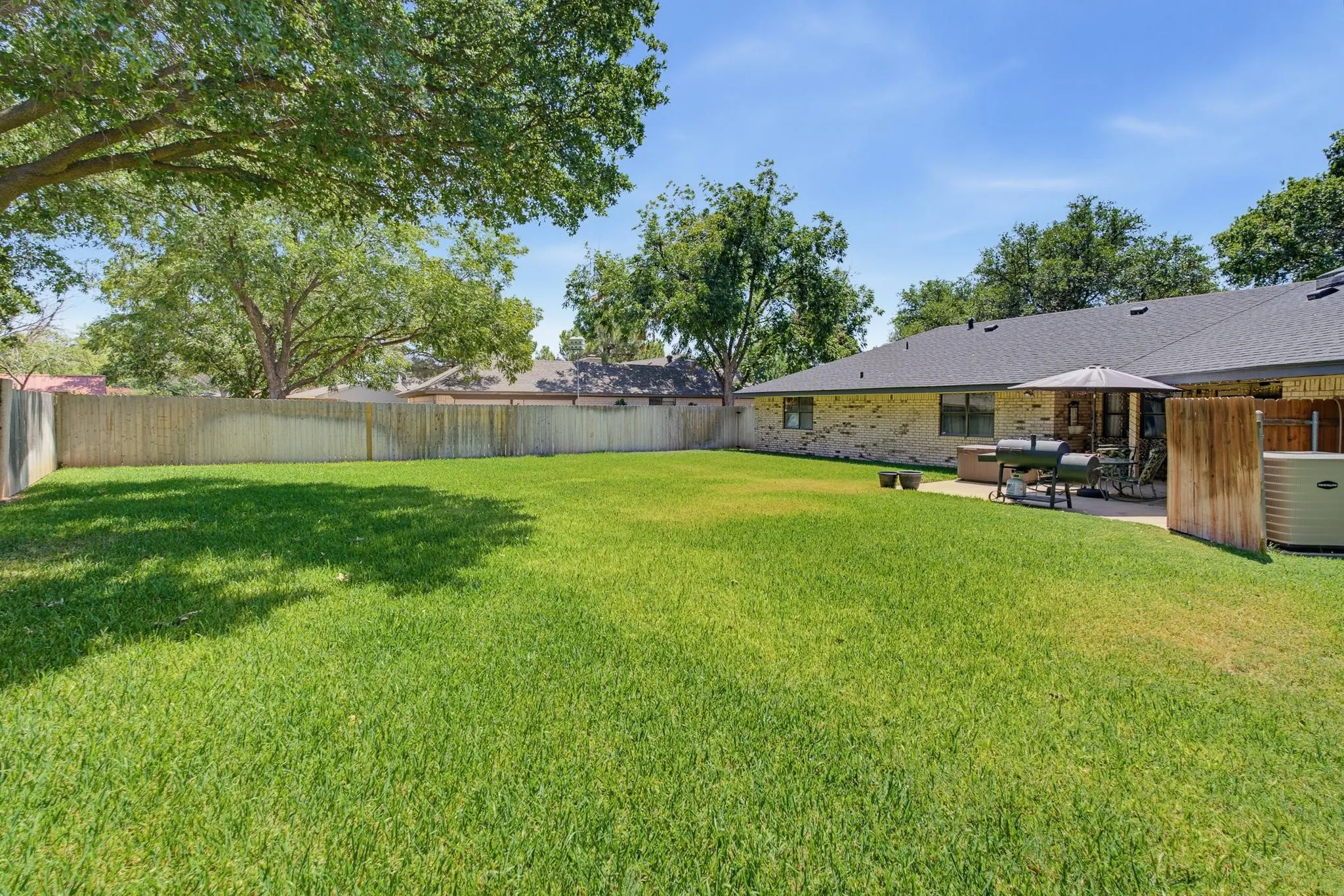 Expansive grass lawn with a full privacy fence