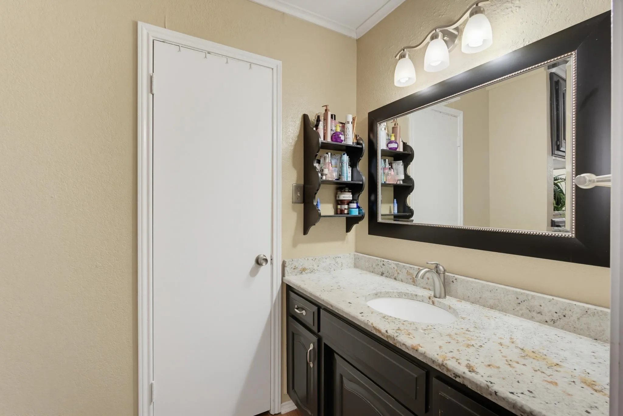 Vanity featuring a single undermount sink, a chrome-finish faucet, and a speckled countertop