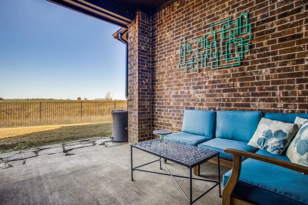 Covered patio with brick wall and concrete flooring