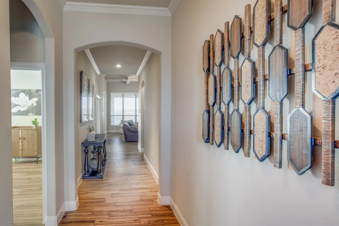 Arched doorways, wood-finish flooring, recessed lighting, crown molding, and high ceilings