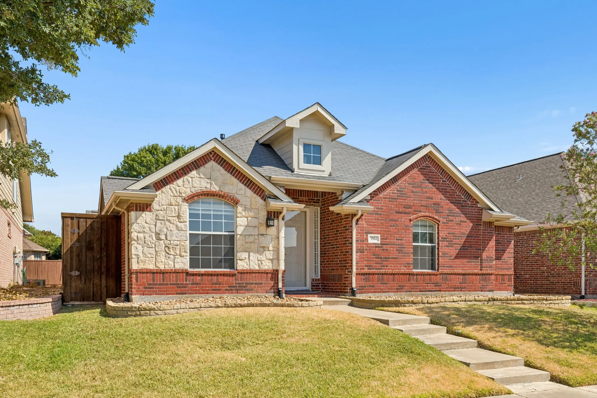 Brick and stone front with concrete walkway