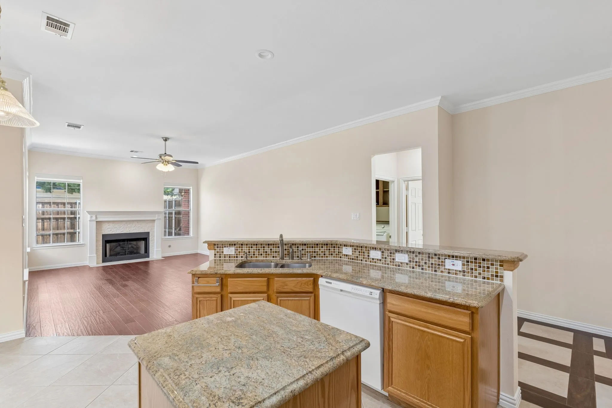 Kitchen with granite countertops, wood cabinetry, and a tile backsplash