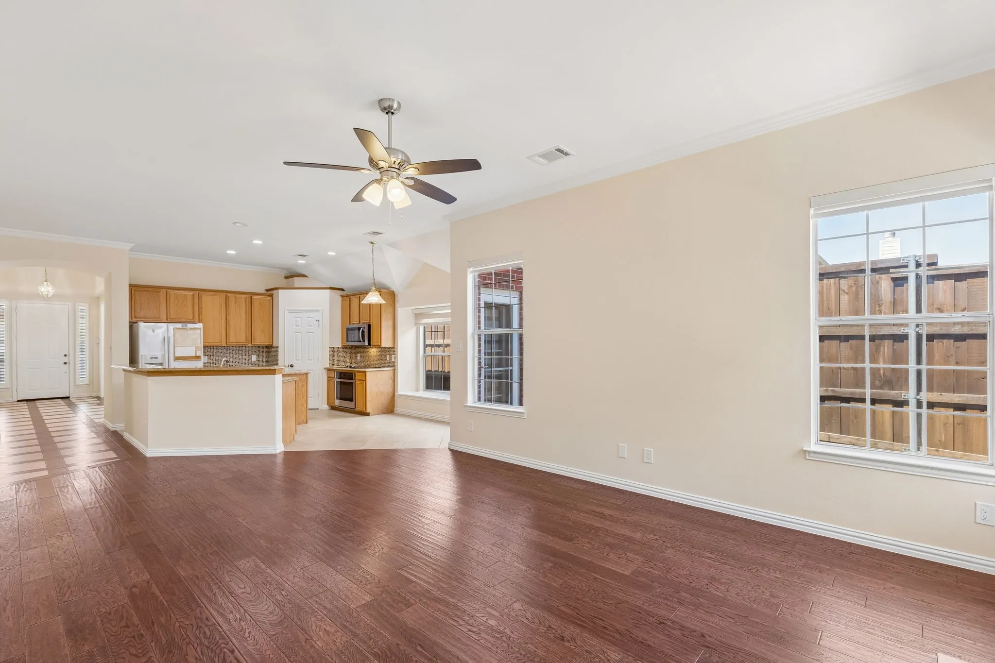 Wood-finish flooring, vaulted ceilings, integrated kitchen bar, built-in microwave, and ample natural light