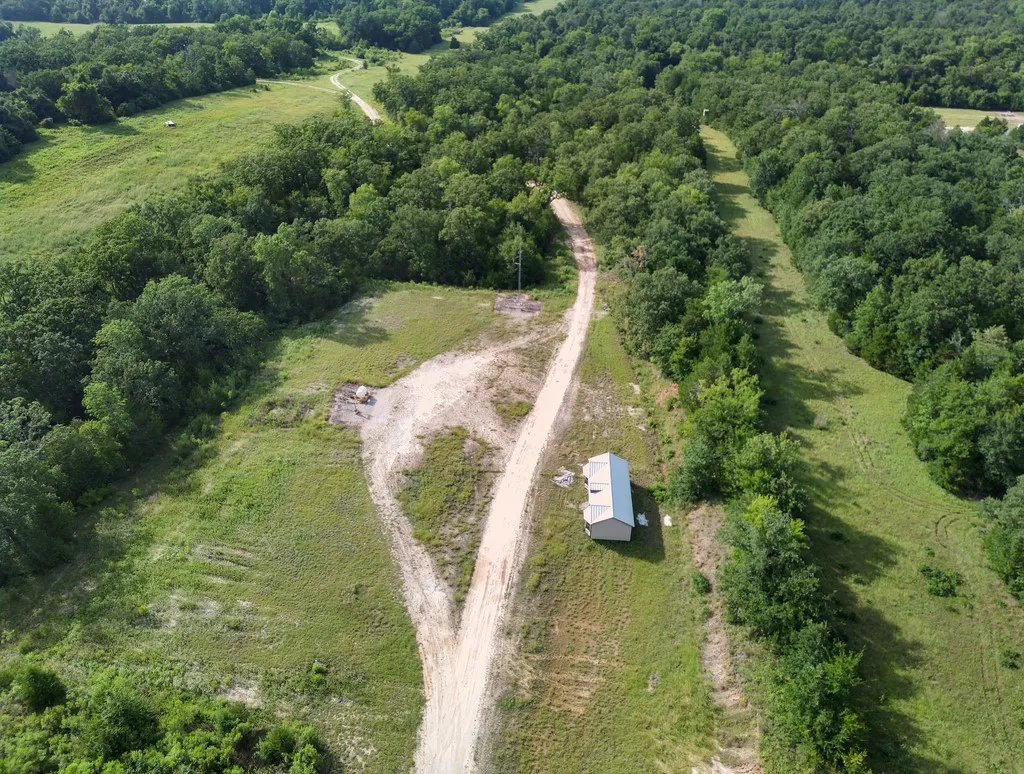 View of property location with a heavily wooded area