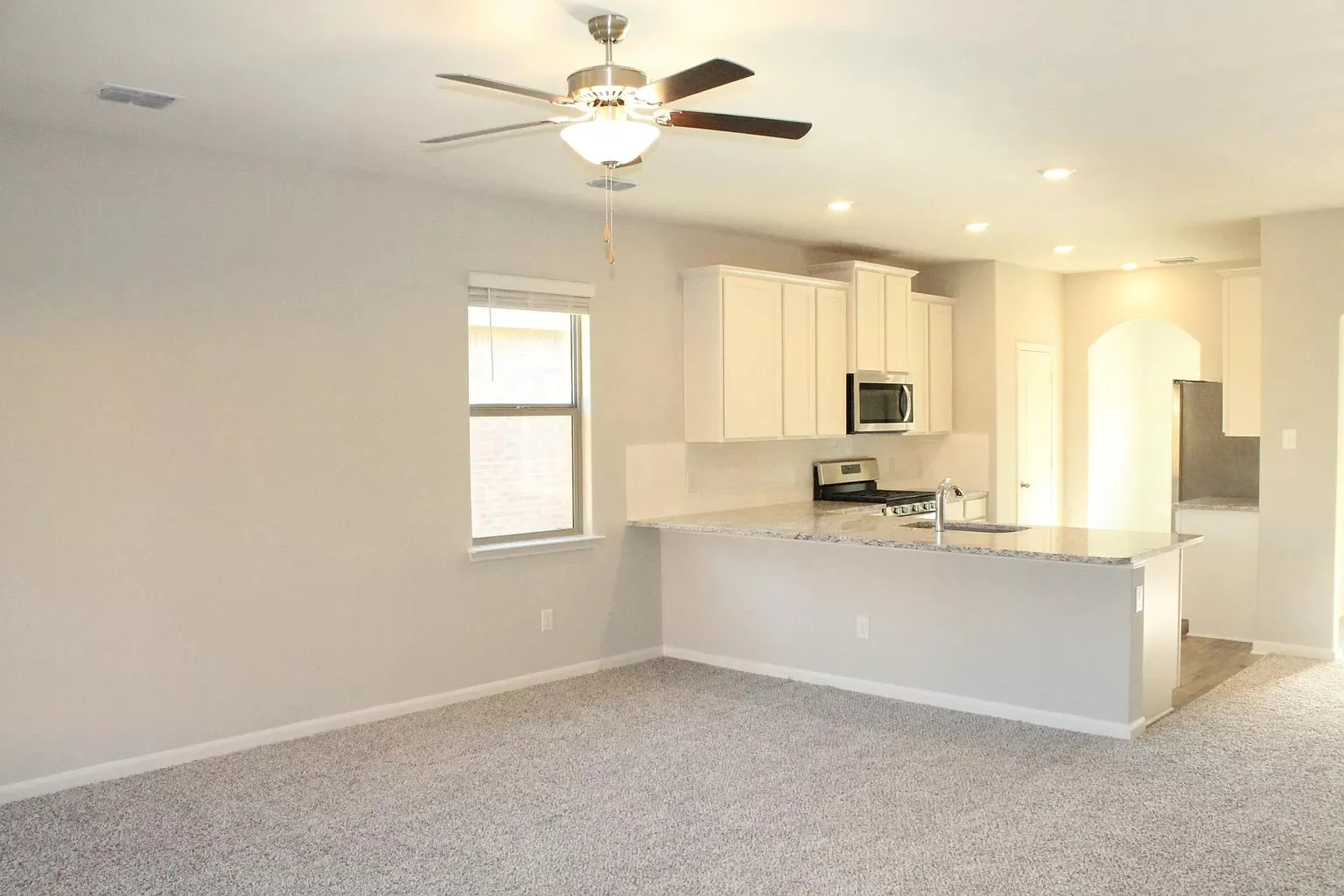 Kitchen featuring light-toned cabinetry, granite countertops, and stainless steel appliances
