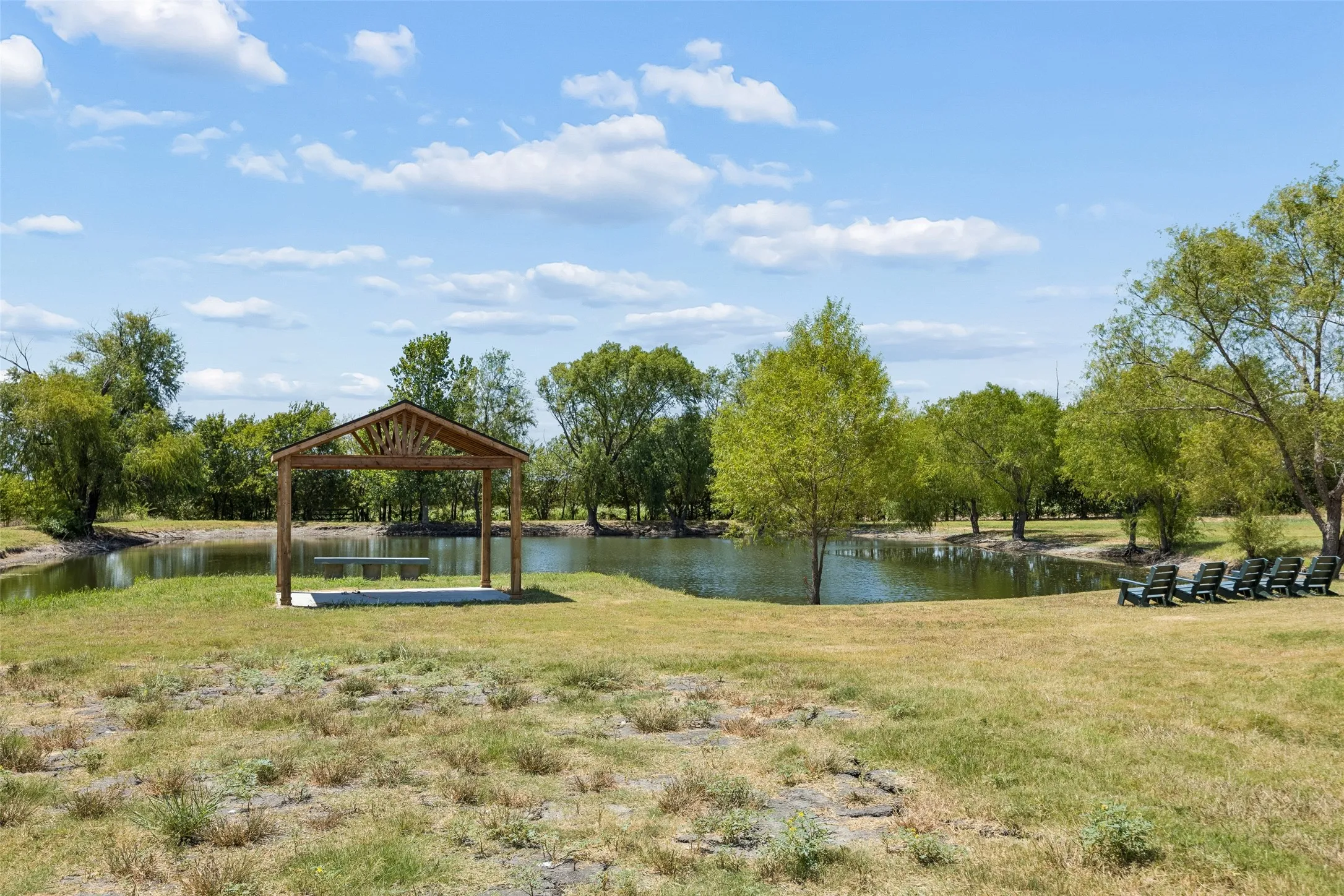 Pond at back of property with arbor and seating