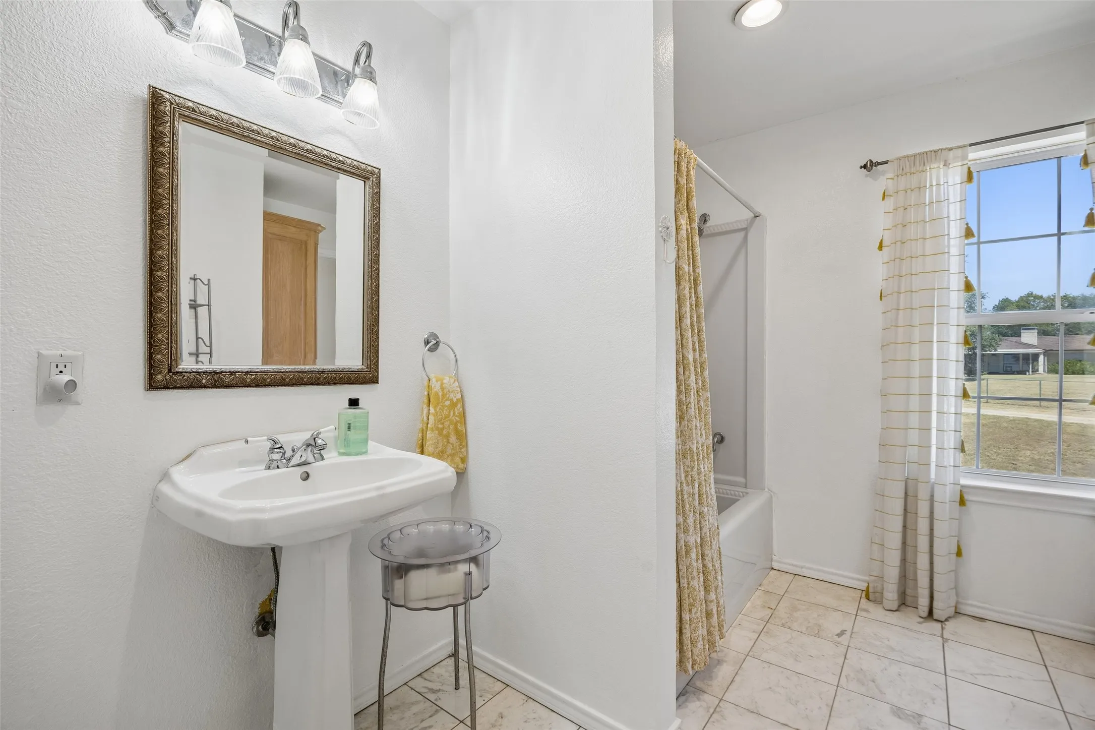 Second floor jack and jill secondary bedroom with Pedestal sink with chrome fixtures, framed mirror, and a wall-mounted light bar