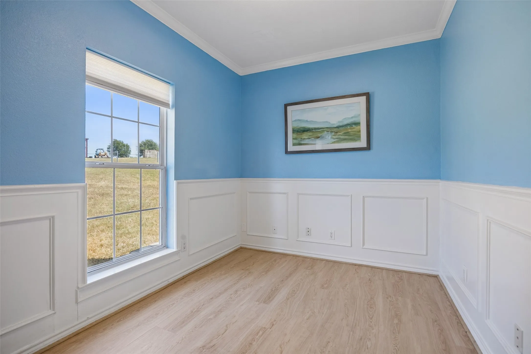 Front study off entry with White wainscoting with panel molding, crown molding, and wood-finish flooring