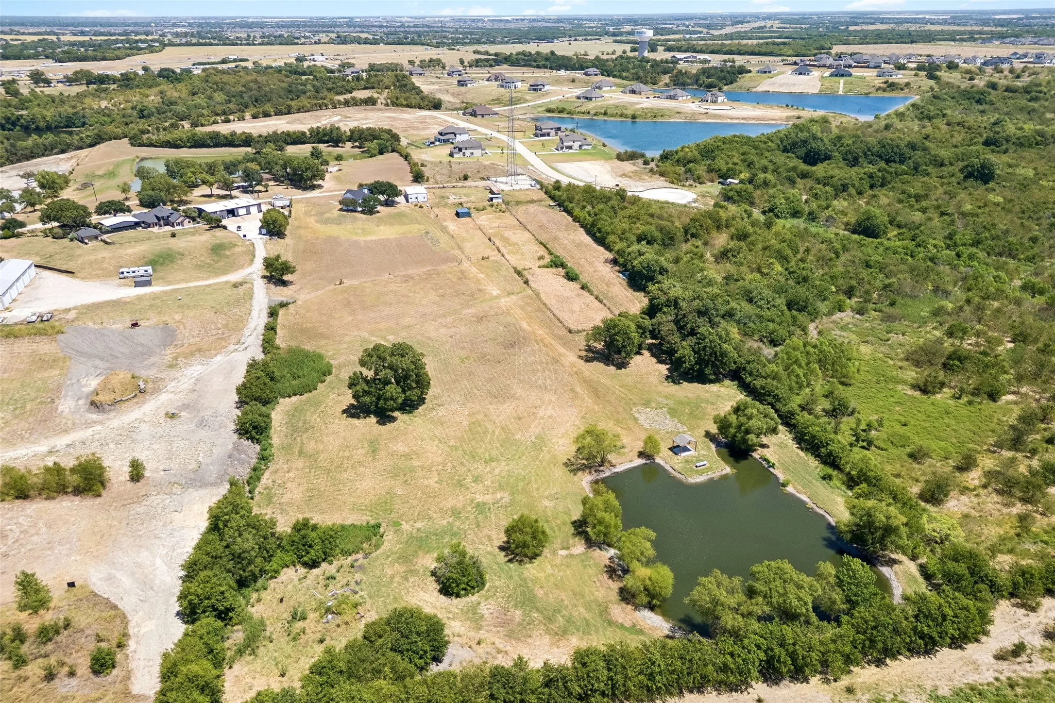 Expansive acreage featuring a private pond, open fields, and wooded areas