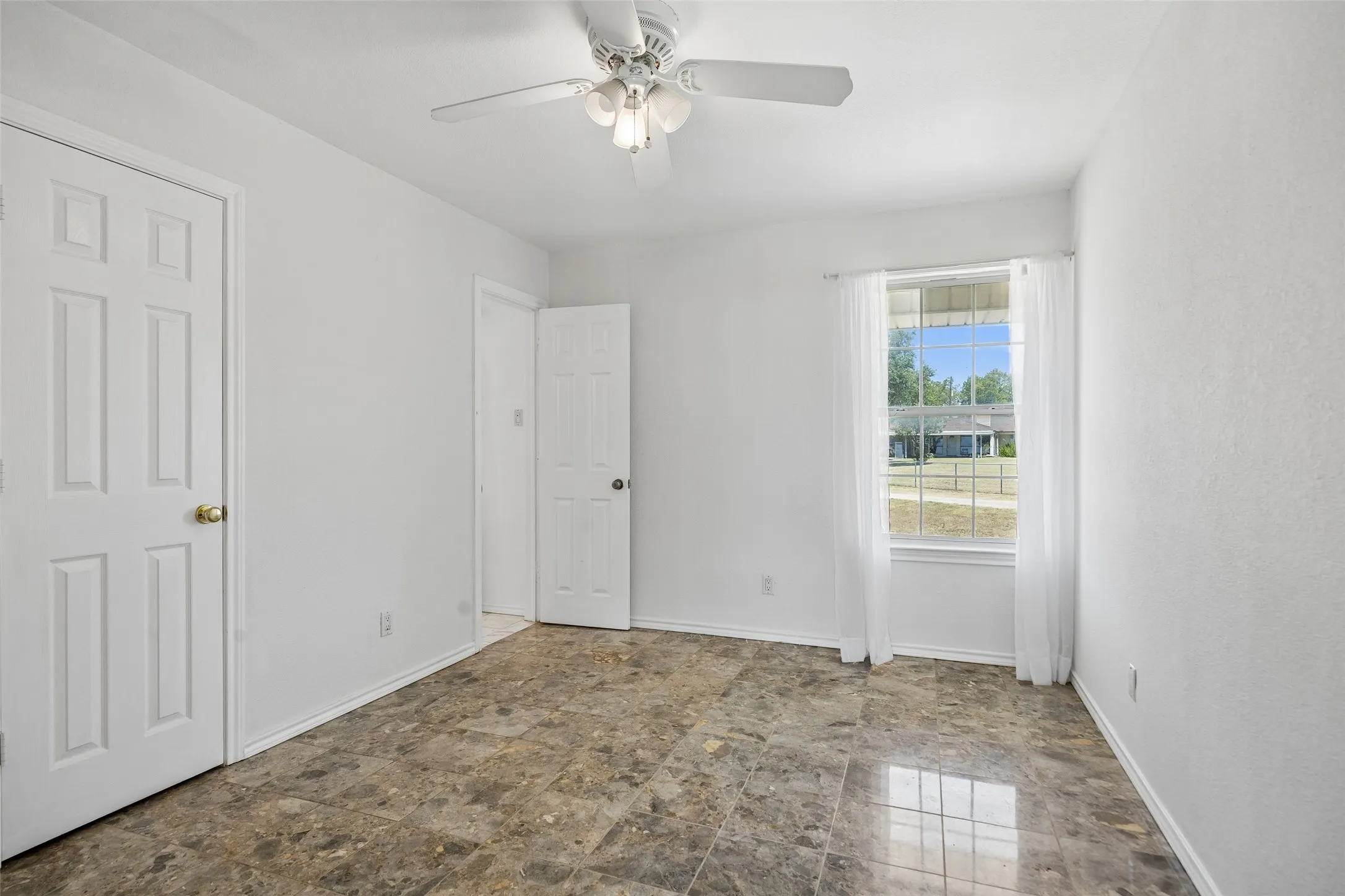 Secondary bedroom 2 with Recessed window with natural light, ceiling fan with light fixture, paneled interior doors, and tile flooring