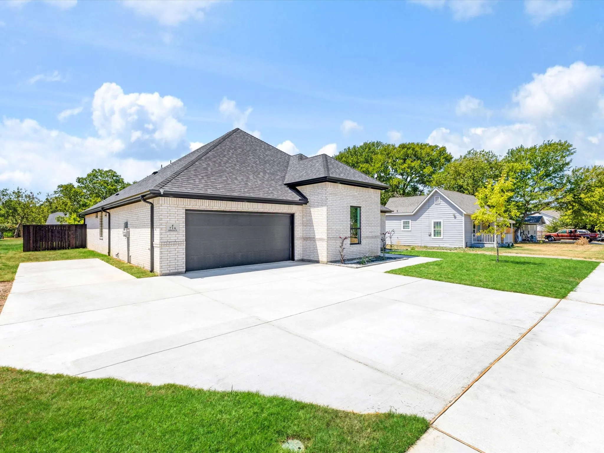 Cream brick exterior with dark shingle roofing