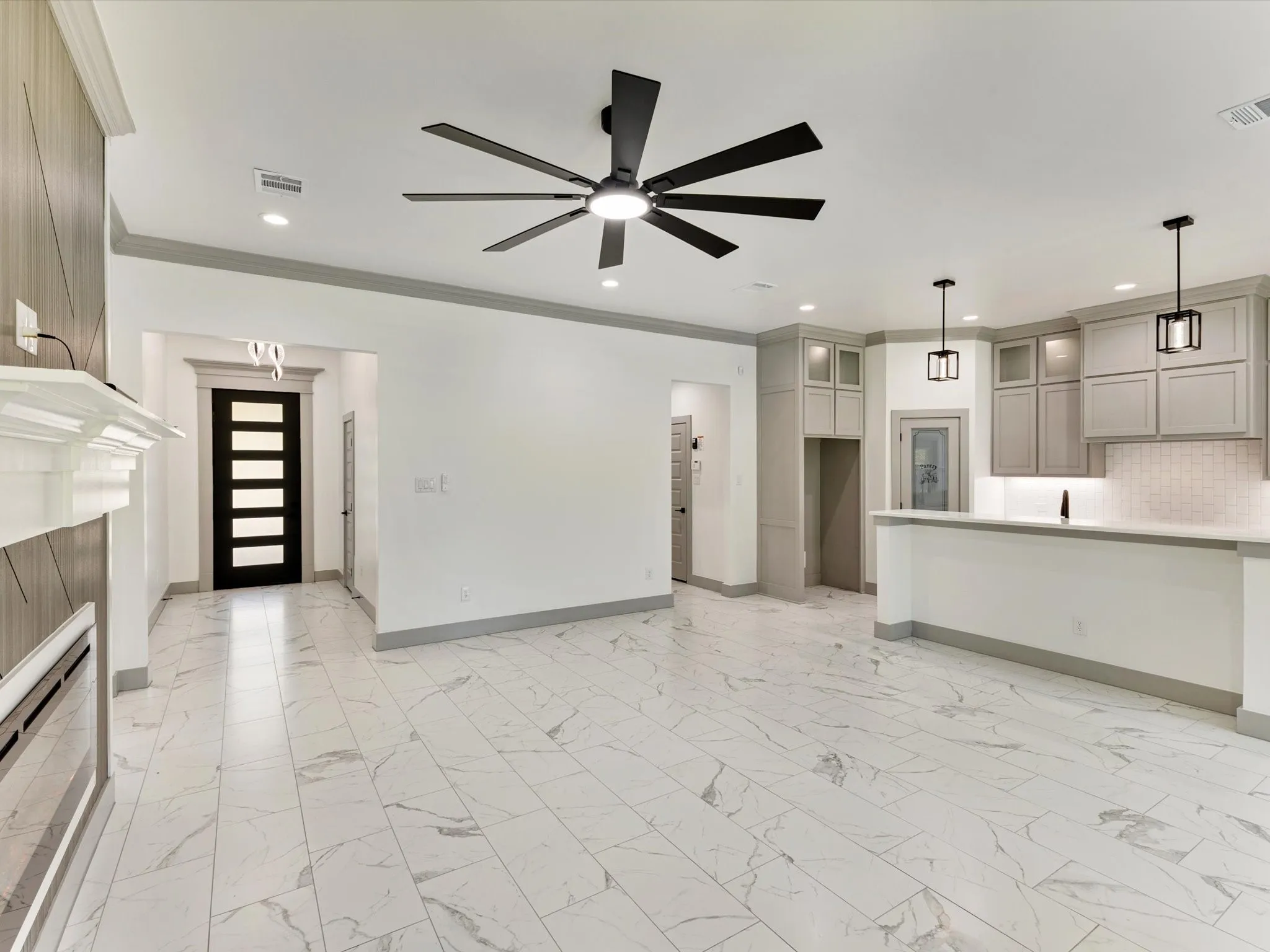 Spacious interior featuring marble-look tile flooring, a modern ceiling fan, and recessed lighting