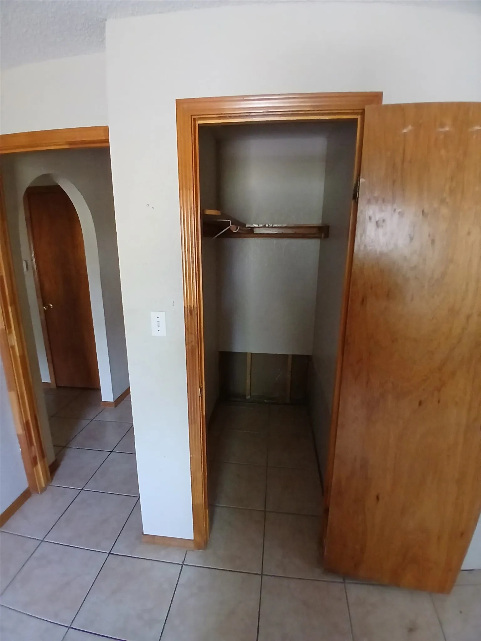 Recessed closet with wood trim and shelving