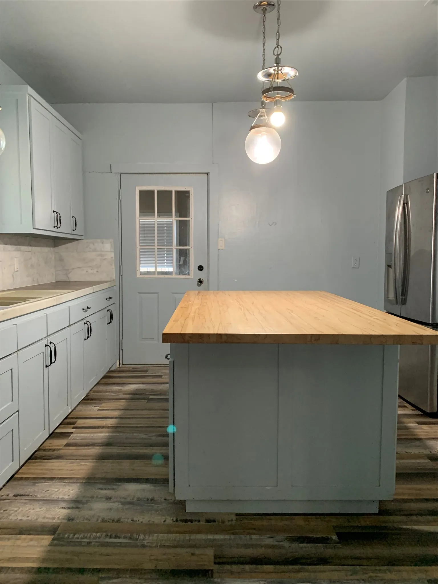 View from the door way into the kitchen. Double sinks on the left and stove. Plenty of  workspace on the large island.