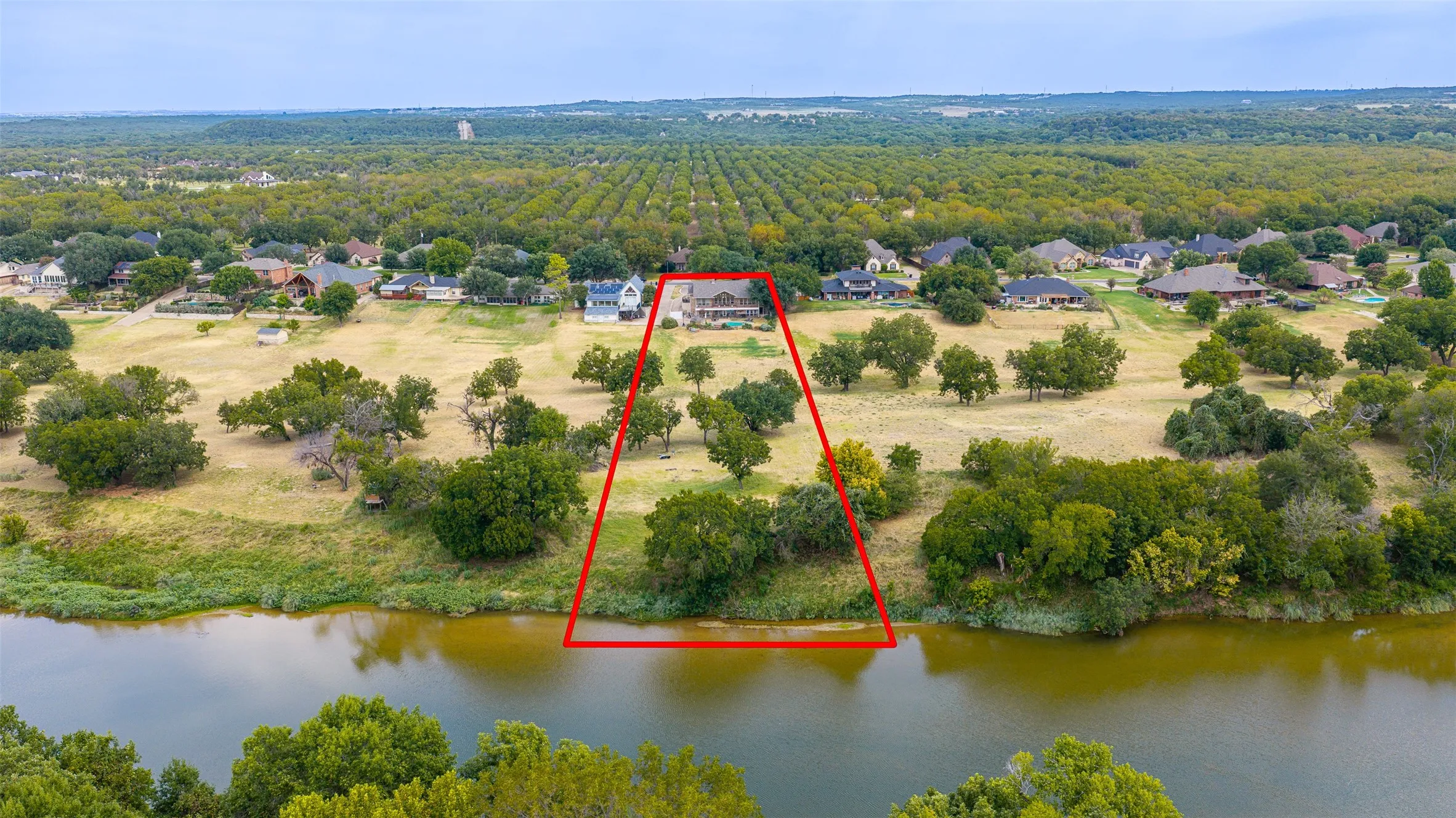 Waterfront property with extensive frontage, surrounded by mature trees