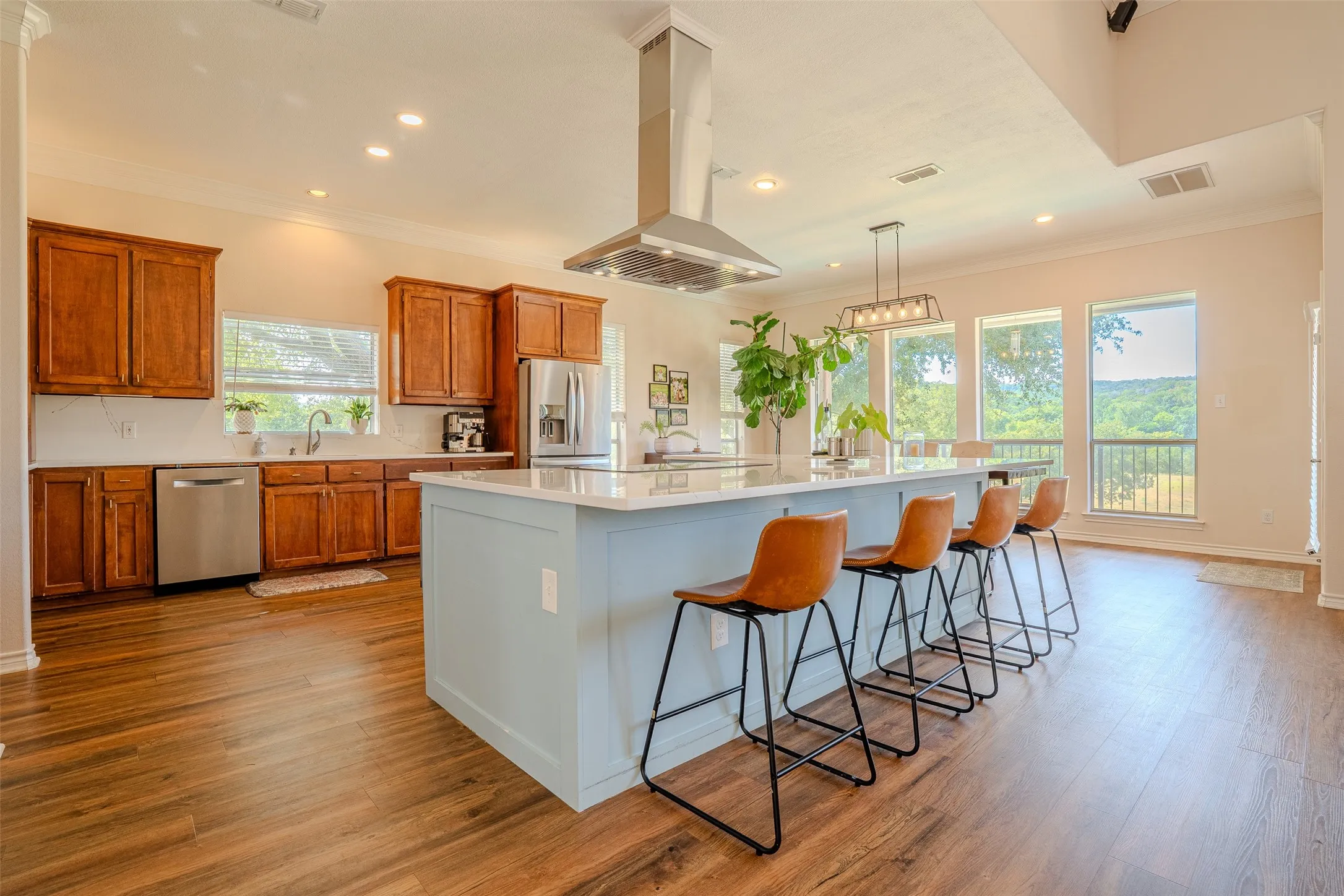 Wood-finish flooring throughout, complemented by a light blue kitchen island with a white countertop