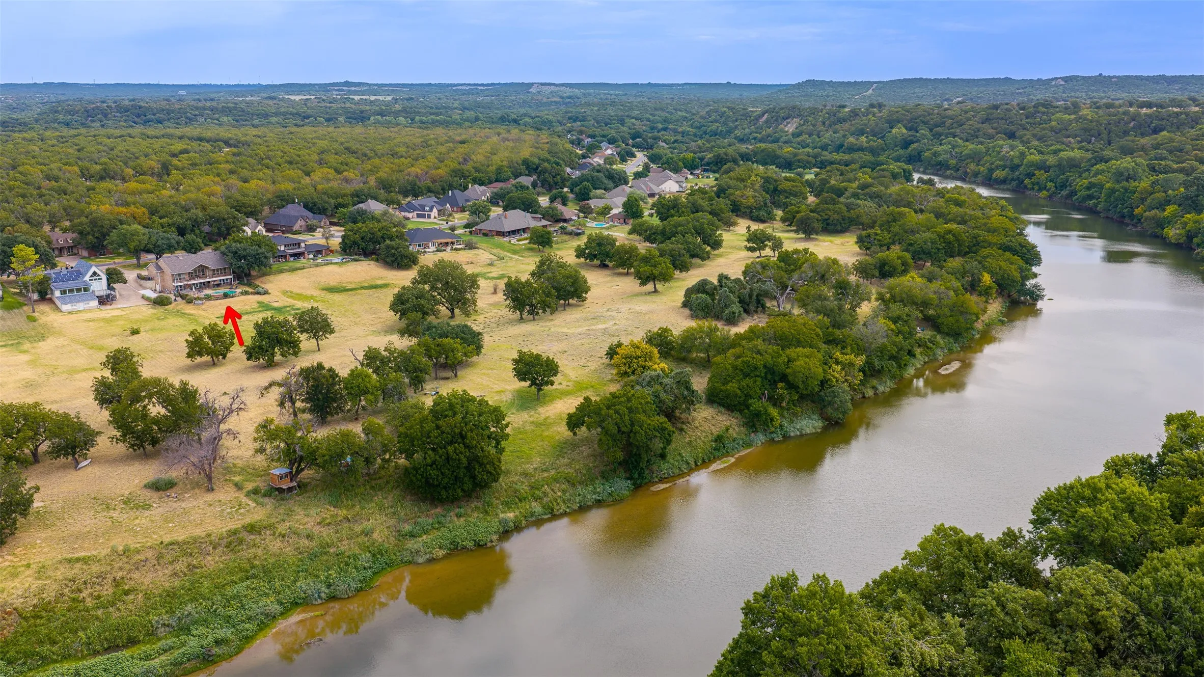 Expansive property with a significant river frontage and a tree-lined bank
