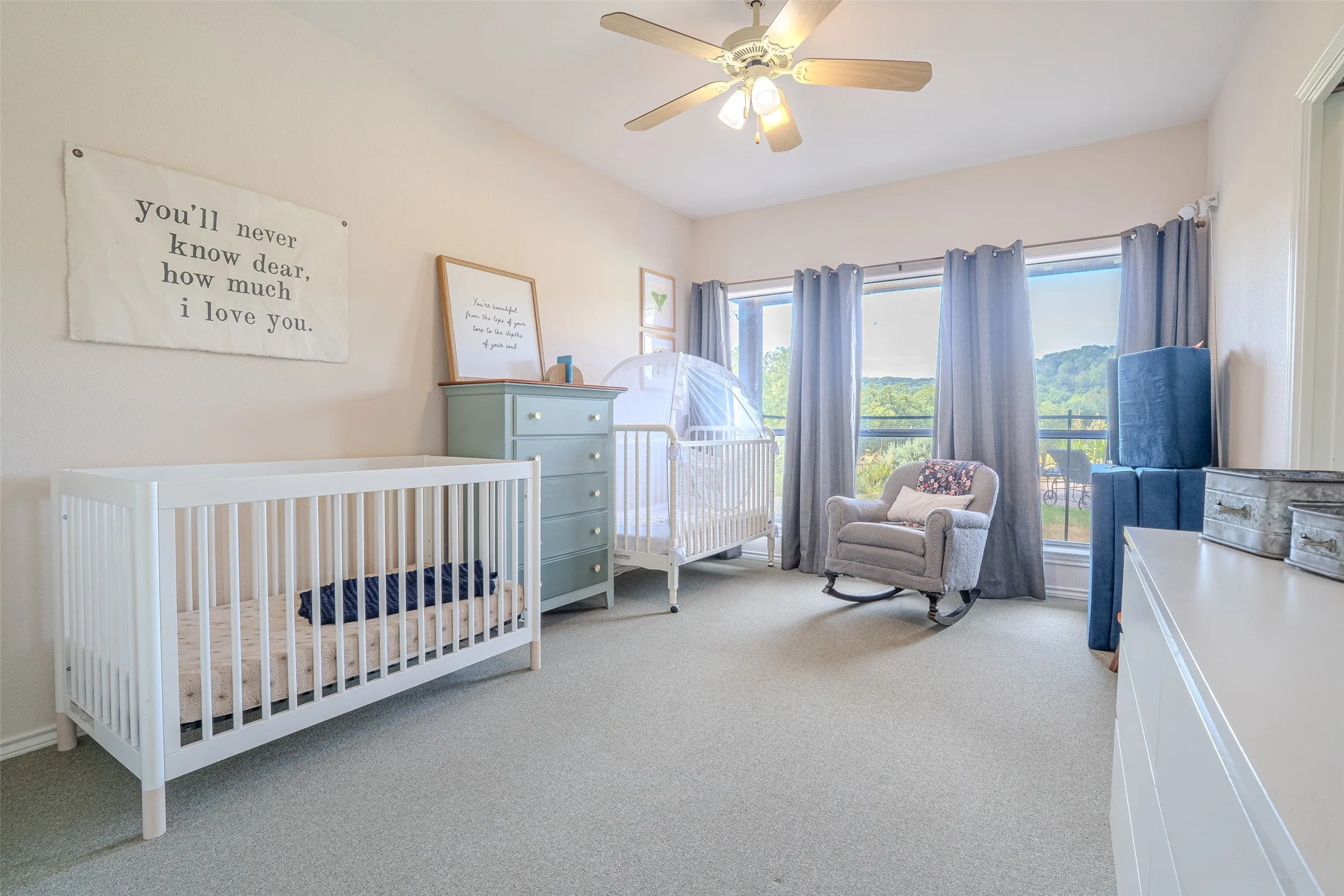 Room featuring light-colored walls, carpeted flooring, and a ceiling fan with integrated lighting