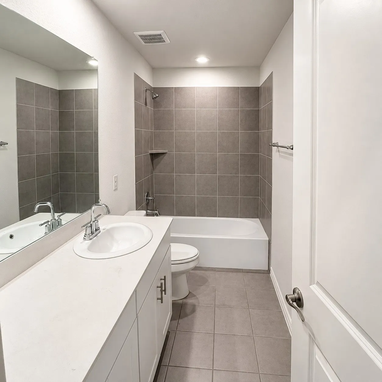 Bathroom with a white vanity featuring an integrated sink, polished chrome faucet, and white cabinetry