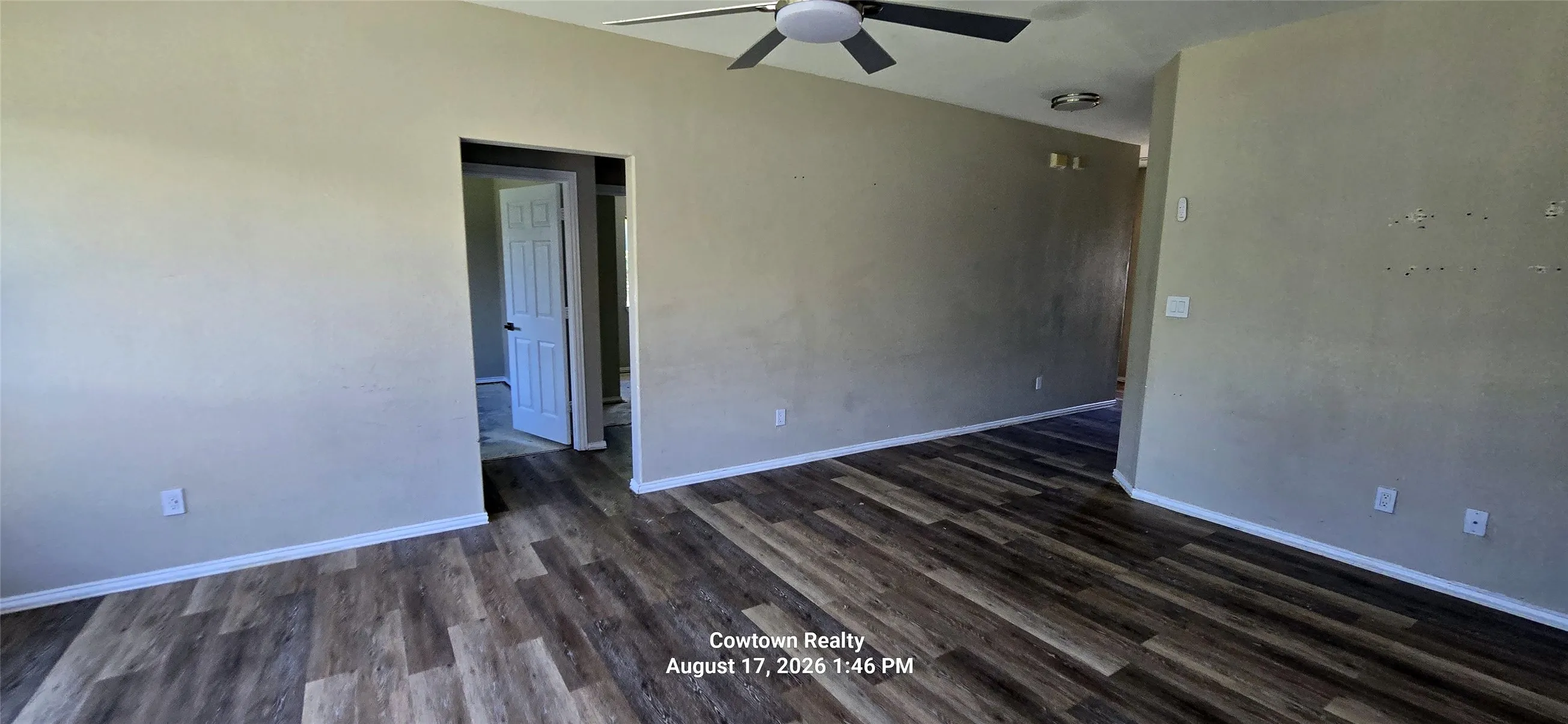 Wood-finish flooring, neutral wall tones, and ceiling fan with integrated lighting