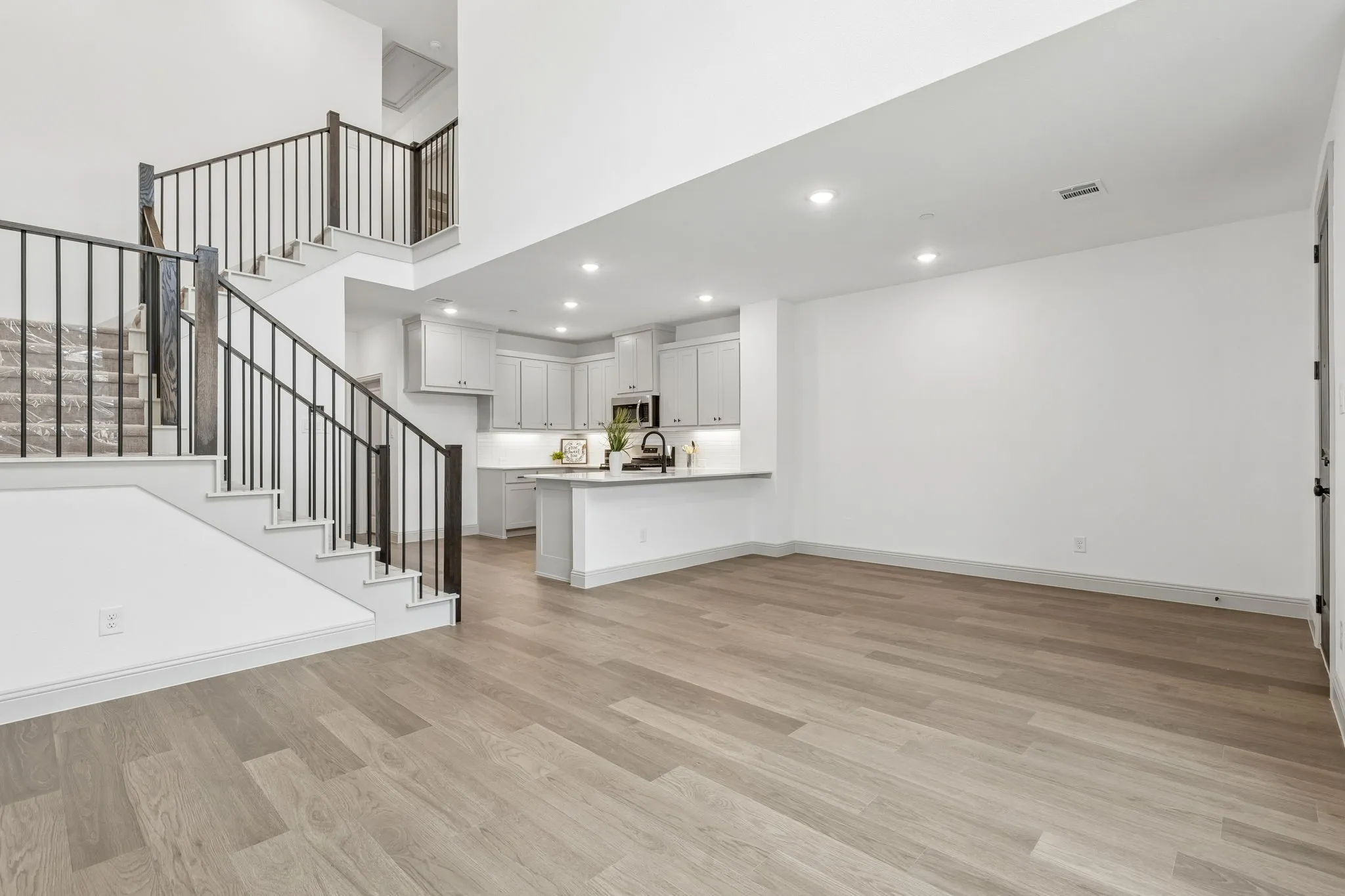 Open railings, light color flooring and a neutral color palette create the perfect gathering space for friends and family!