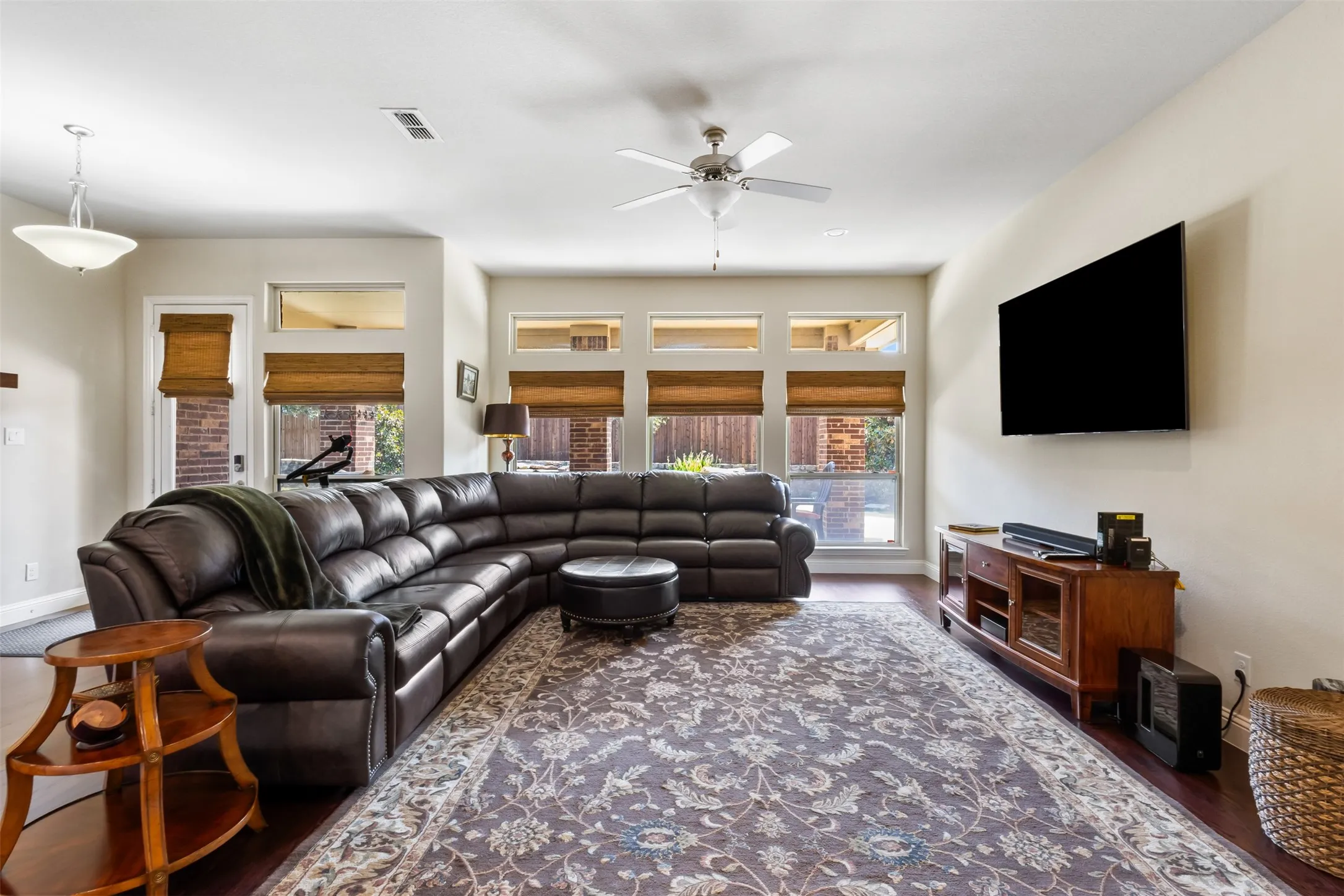 Wood-finish flooring, recessed lighting, and multiple windows with upper transoms