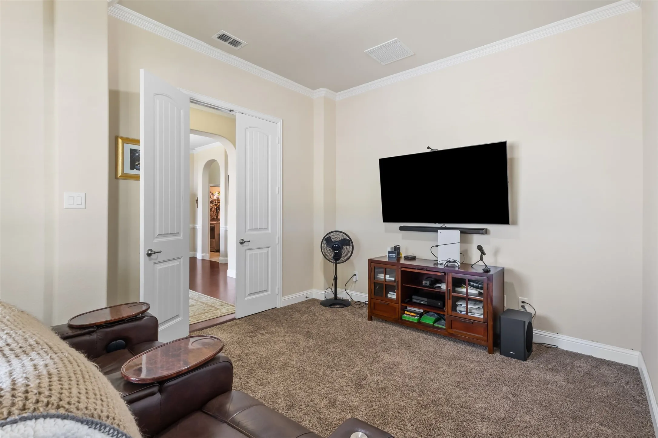 Neutral wall tones, white crown molding, and recessed ceiling lighting